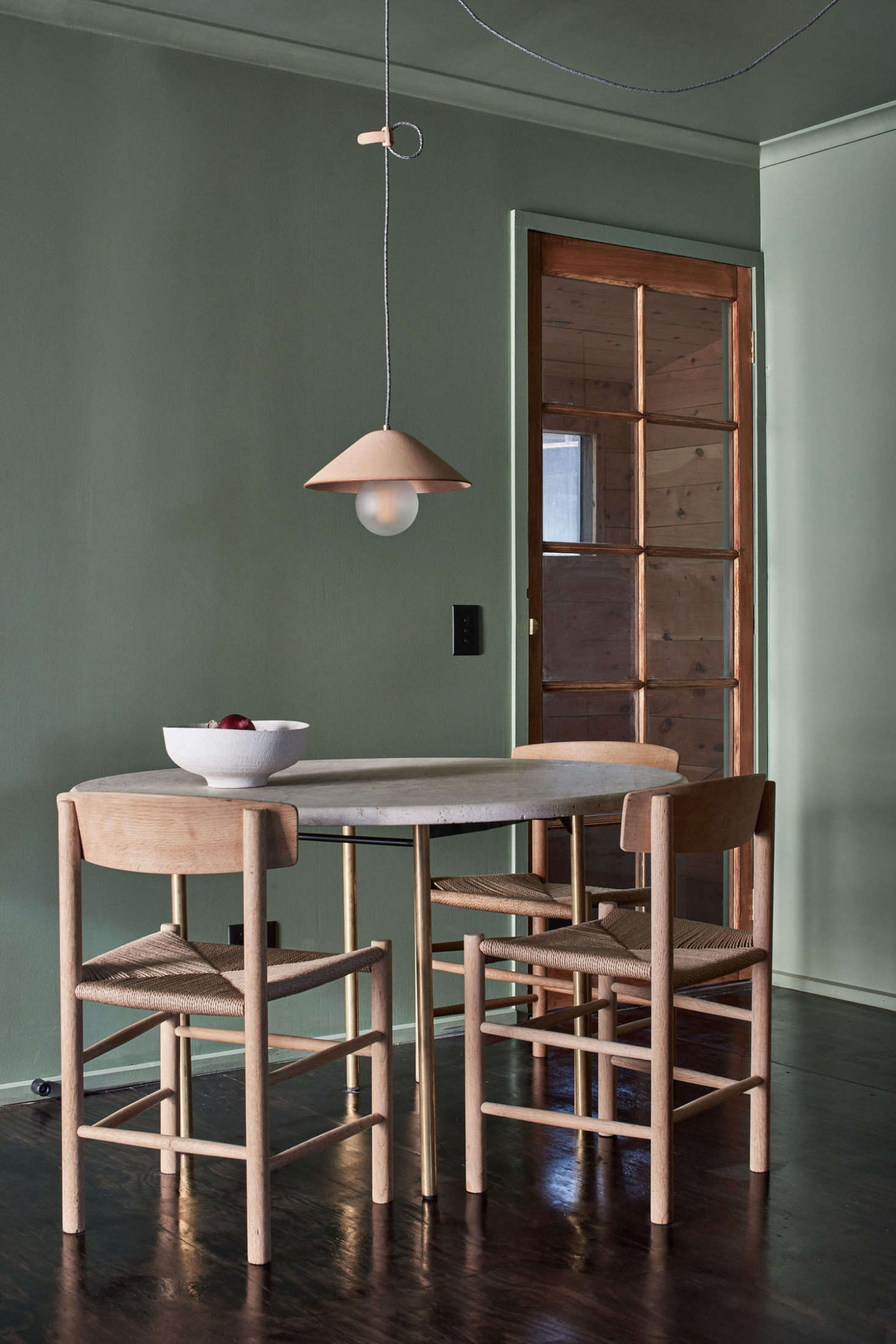 The combination of soft green and pale wood continues in the dining area. 