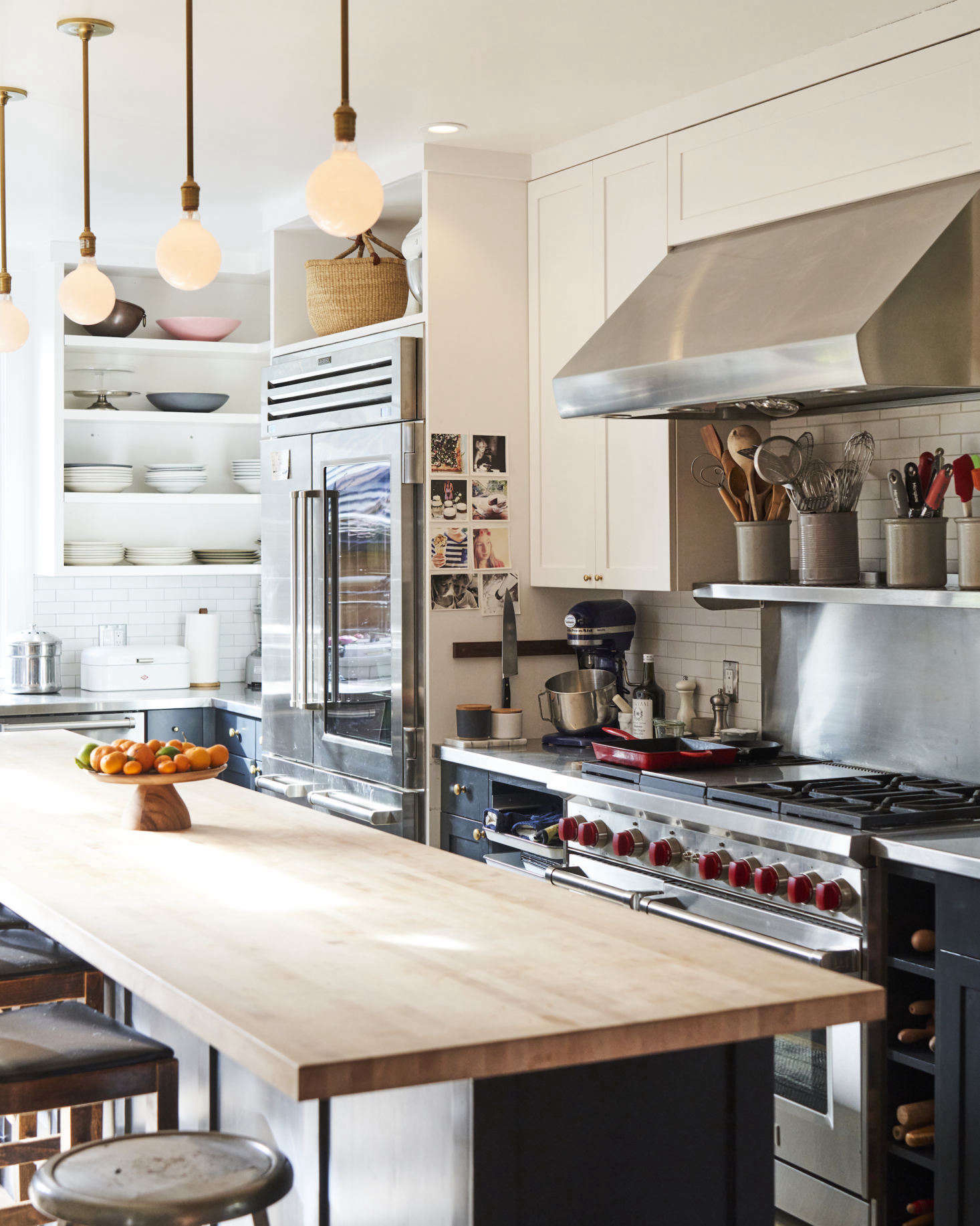 Other restaurant kitchen-inspired touches include a speed rack (to the left of the stove), dedicated cubbies for rolling pins (to the right of the stove), and open shelving for easy access to tools. Phyllis notes that having open storage may not be for everyone. It requires 
