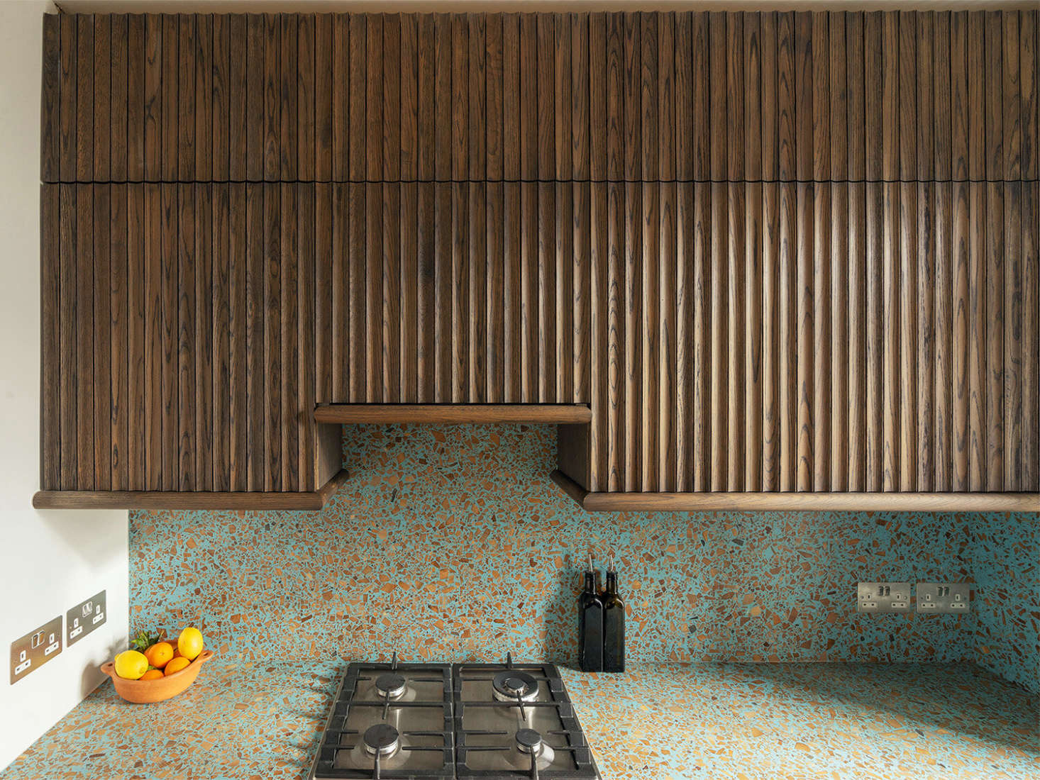 Fluted oak cabinets meet terrazzo in a compact London kitchen by Surman Weston architects. The counter and backsplash are Foresso, a composite sheet material made from, among other things, scrap wood, waste from sawmills, and waste lime plaster.