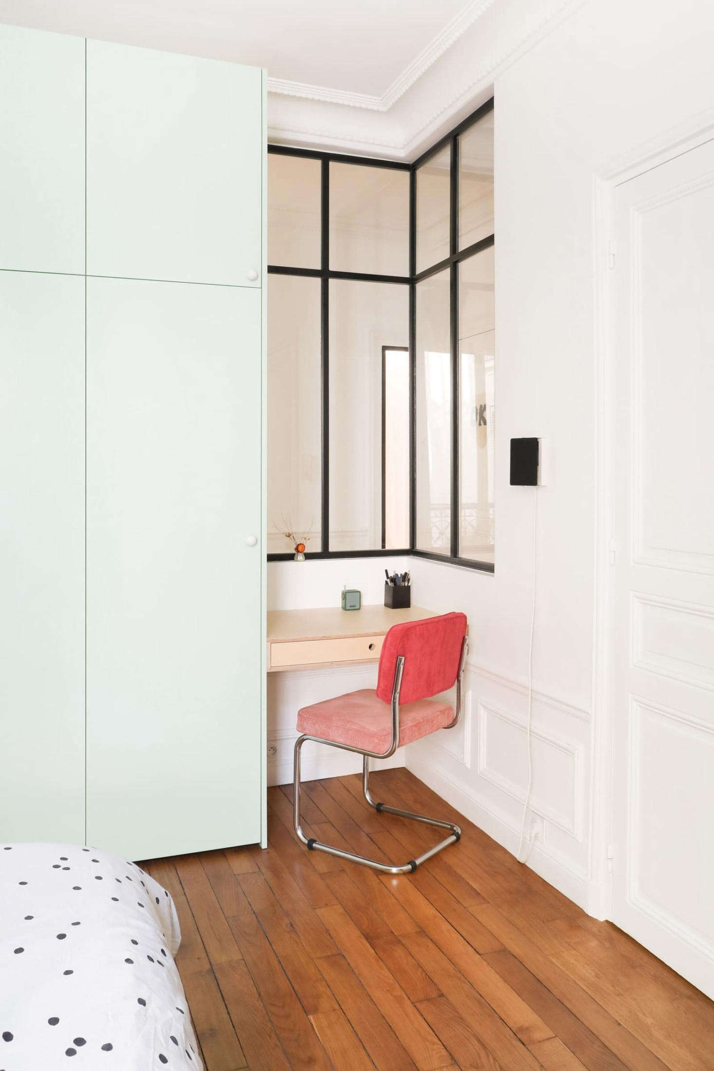Hélène and Julien tucked a work niche next to the cabinets, and inserted an interior corner window that visually enlarges the space and brightens the hall. 