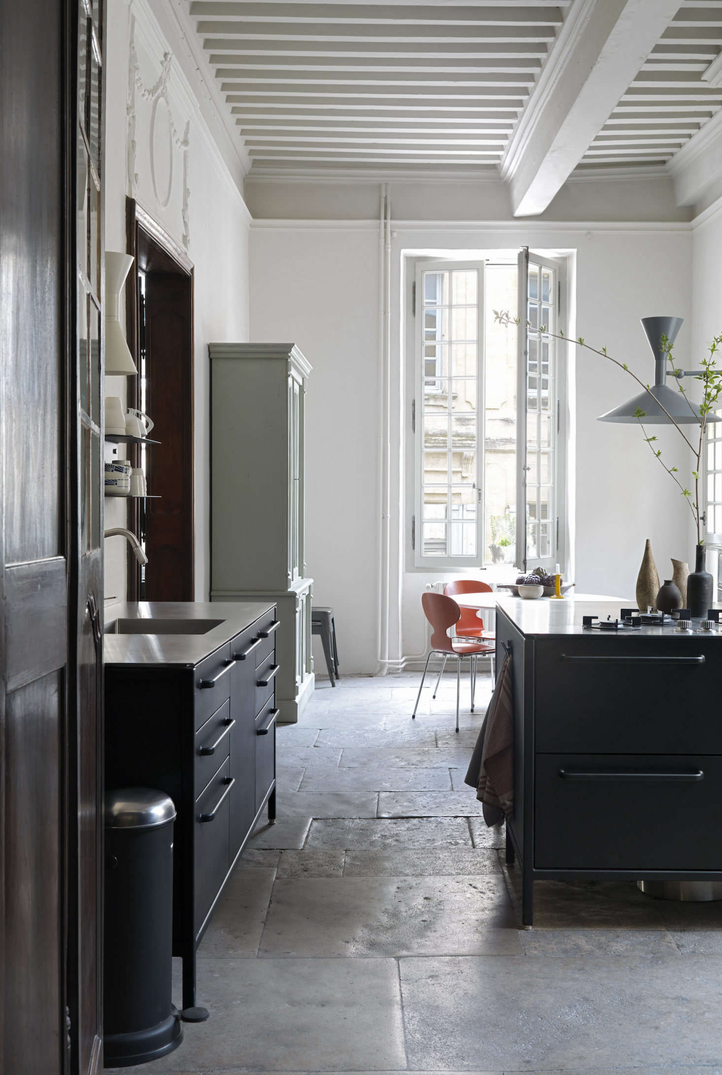A vintage painted hutch offers a warm contrast in the kitchen. Note the -foot-high ceiling.