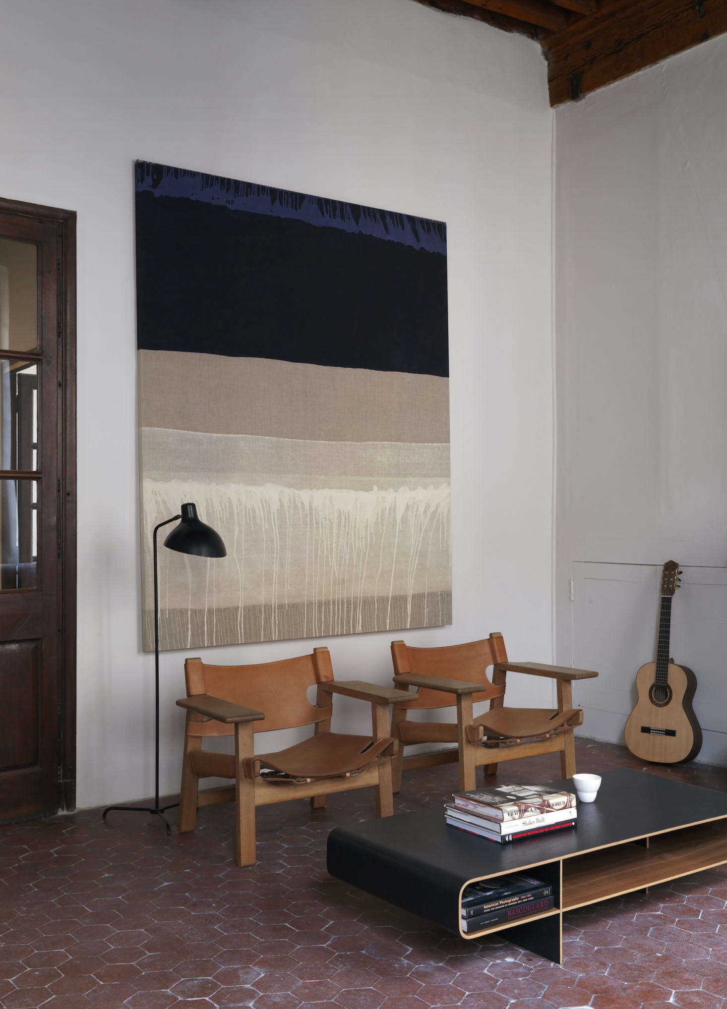 A painting by Kate Blee hangs behind Spanish Chairs by Børge Mogensen. Note the other piece of art in the room: a guitar made by Chris.