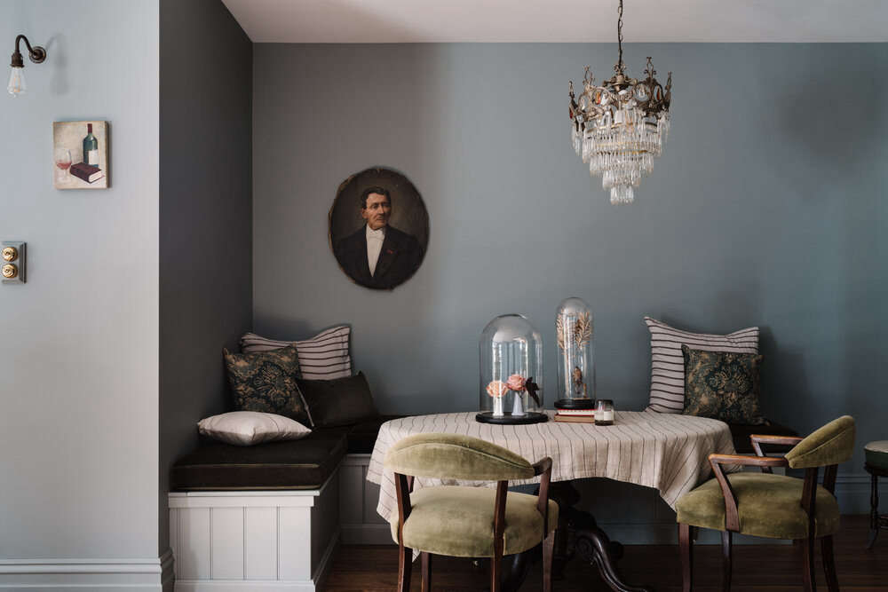 The dining nook is fitted with built-in banquettes and mossy velvet cushions.