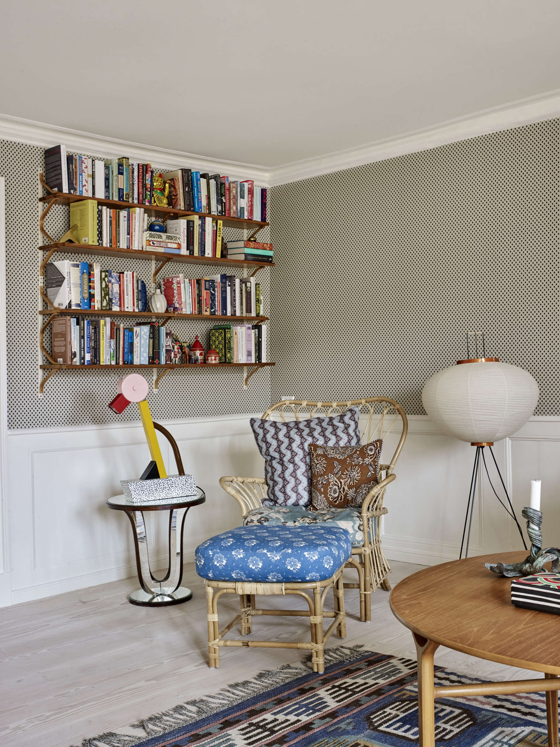 In the library corner of the room, Tina layered patterns on a rattan chair and paired it with Ettore Sottsass