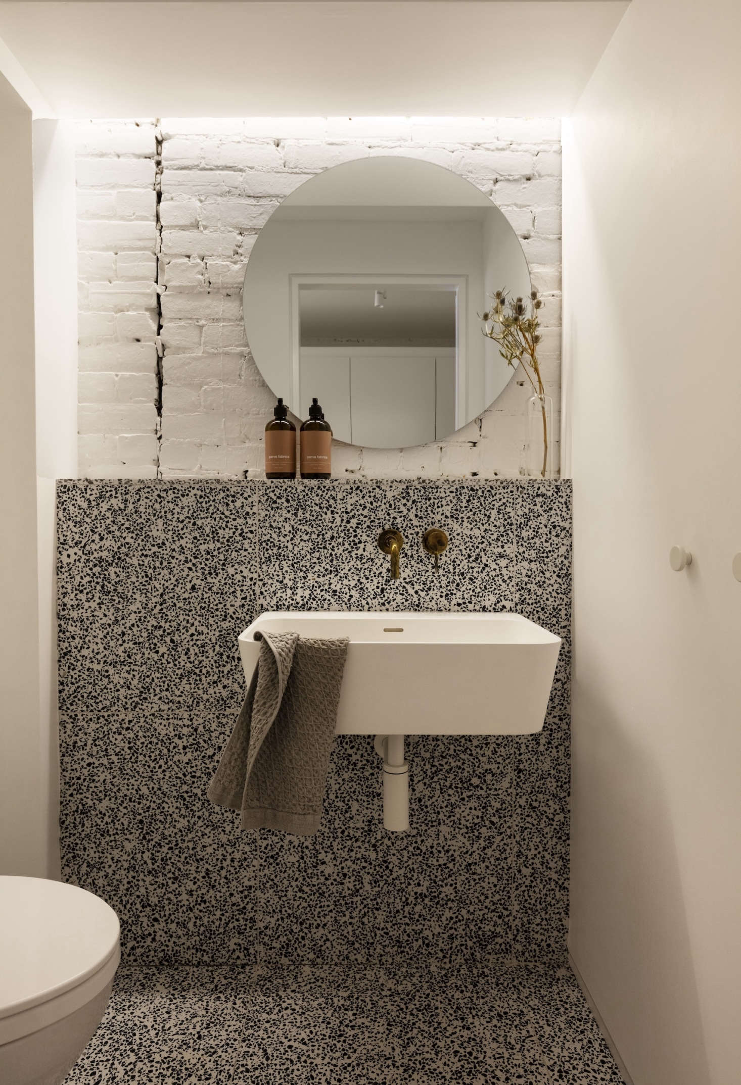 The terrazzo powder room, featuring a sink from Porcelanosa.