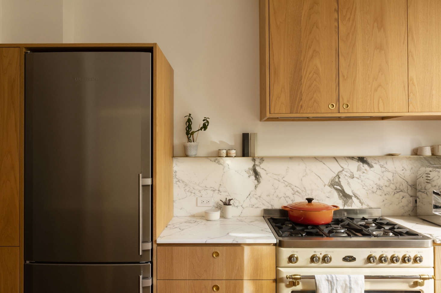 The custom oak cabinetry is by Éco-Ébénisterie Saint-Dominique. A slim shelf rests above the backsplash.