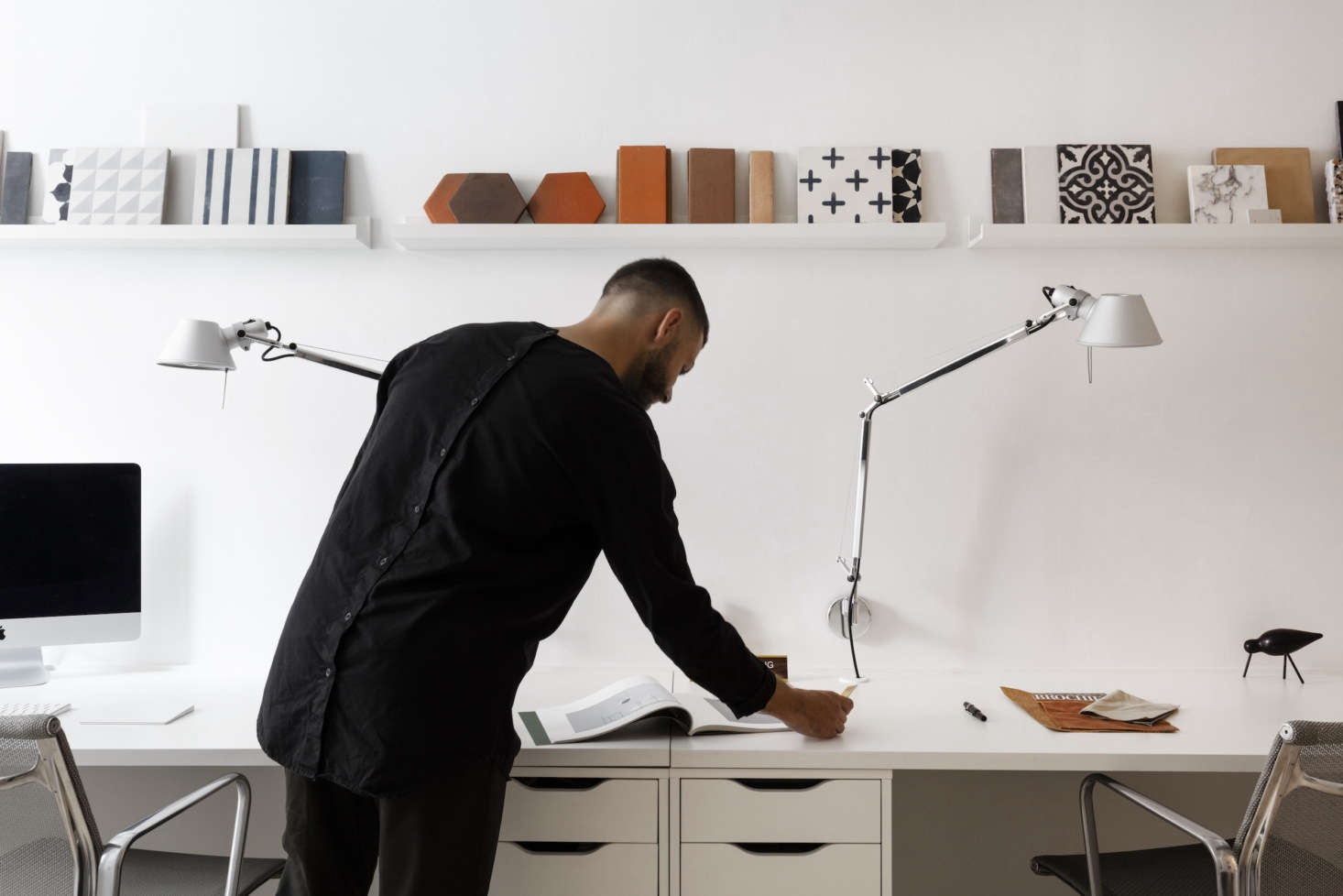 Michael in front of simple built-in desks and a display of tile samples. Under the desk are two Alex Drawer Units from Ikea.