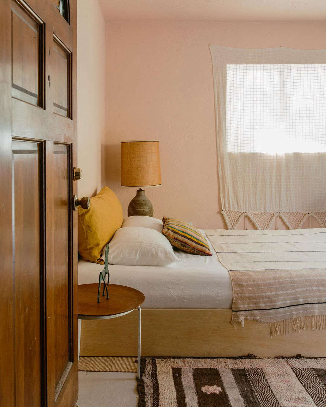Each bedroom has a simple platform bed and subtly pink walls.
