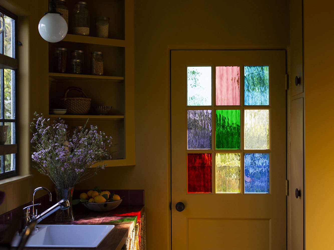 An unexpectedly pretty side door, thanks to colored glass panels (from Sunshine Glass) that replaced the standard clear ones.