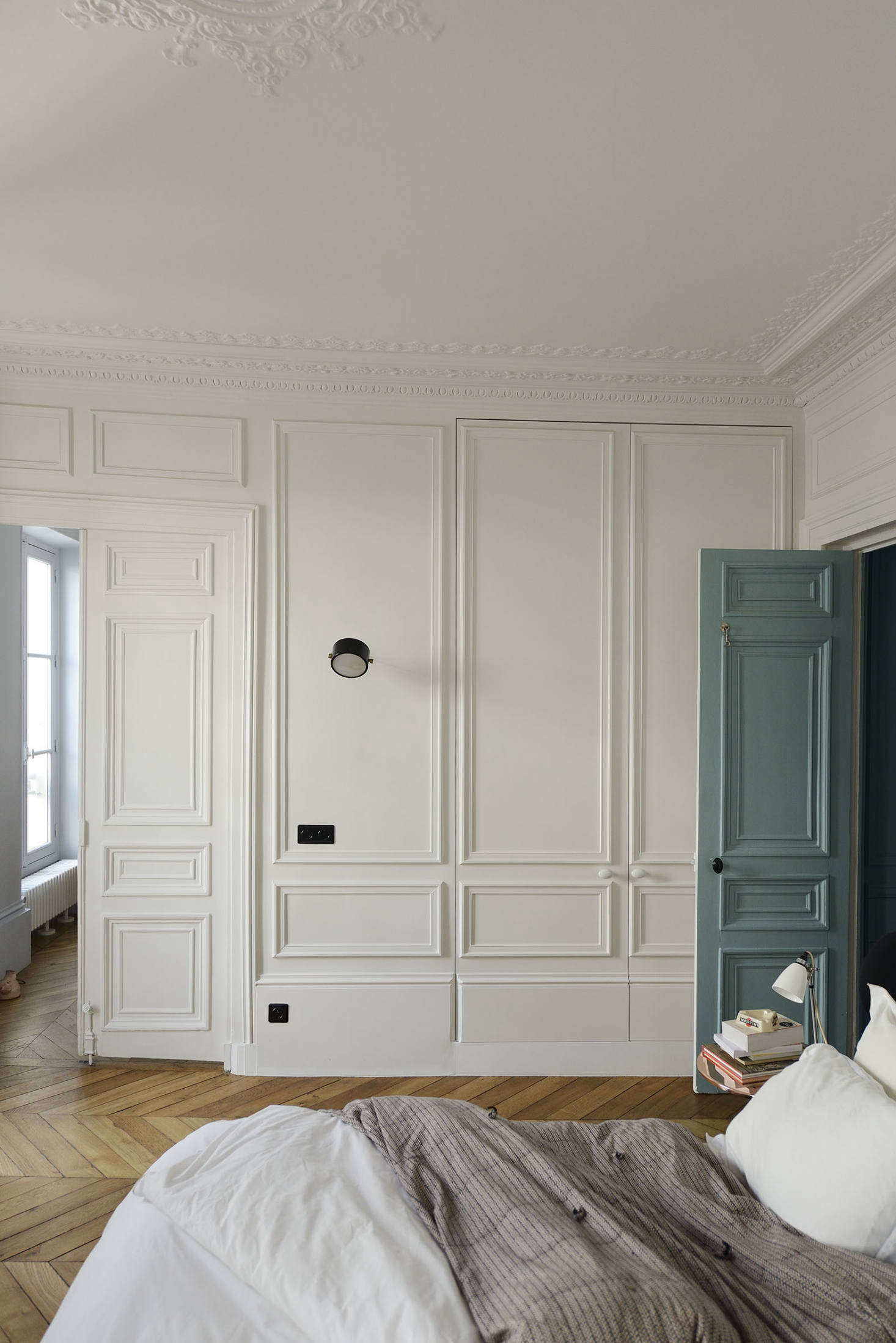 The architects made up for a lack of closets by building in a wall of cabinets with paneled moldings to work with the original plasterwork on the ceiling.