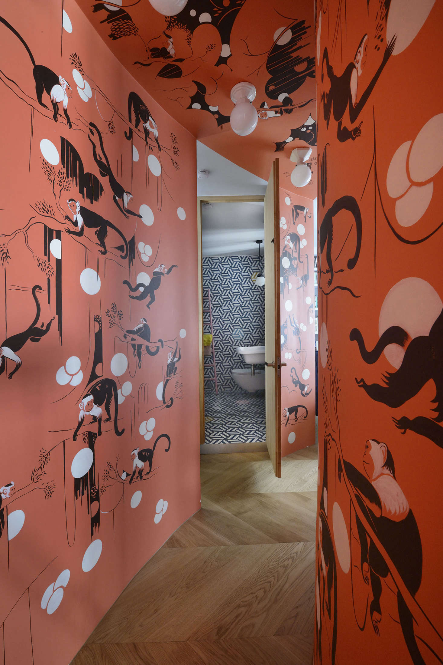 The hall was initially going to be covered in a de Gournay monkey-patterned wallpaper. On realizing that the ceiling would be hard to paper, the architects came up with the idea of recruiting graphic designer Lewis Heriz to paint his first mural.