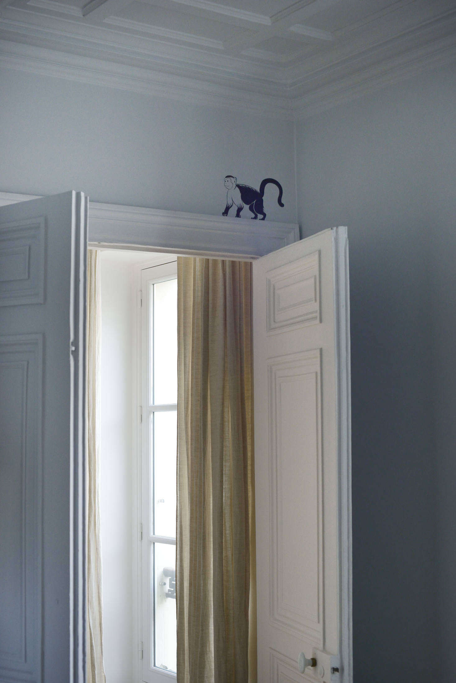 Lewis Heriz, the London graphic designer who was recruited to paint the monkey-patterned hall, also left his mark here and there in the apartment, including over the door to the primary suite.