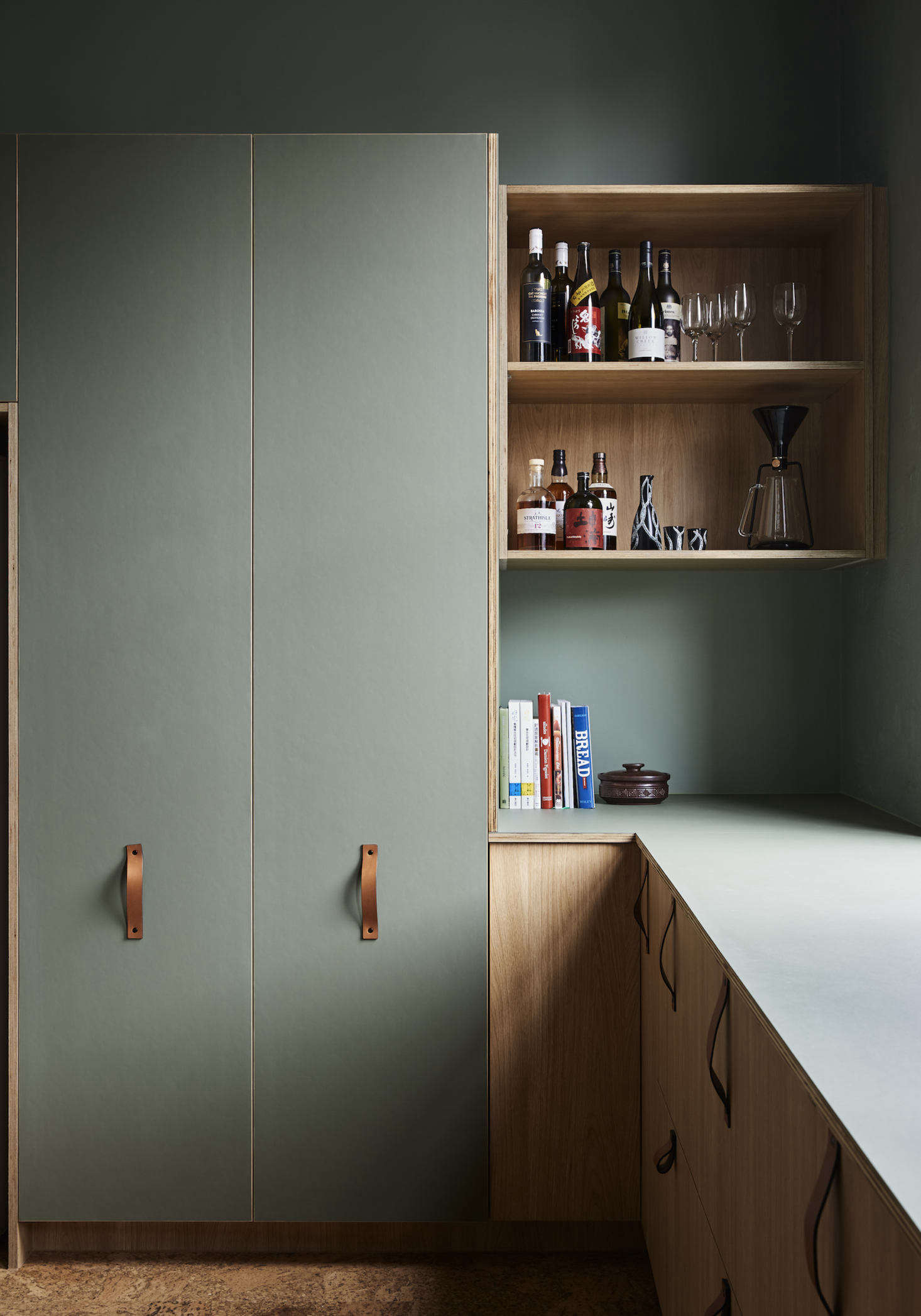 The kitchen cabinets were custom-made by MTR Designer Cabinets using Laminex boards in Elegant Natural Oak finish. The pantry features doors fronted with with green panels of furniture linoleum by Forbo. The same linoleum was used to top the -mm birch plywood countertop as well.