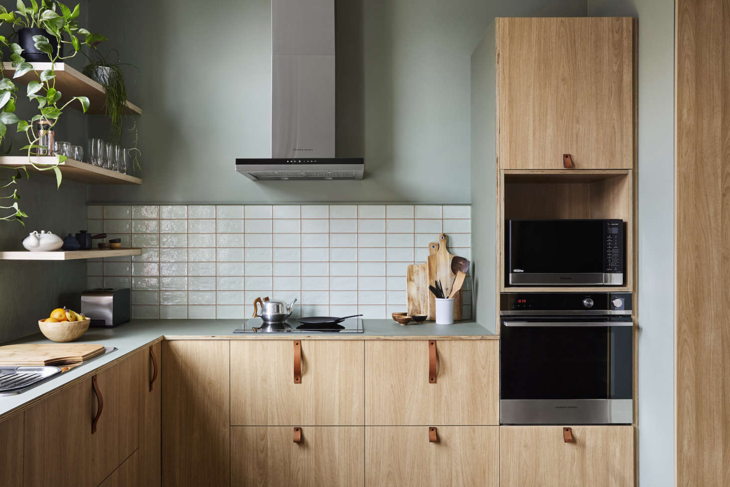 The kitchen references the outdoors with sage-green accents. On the walls here is Dollar by Australian paint company Dulux. The tiles are from the Piemonte collection (in apple) by Classic Ceramics.