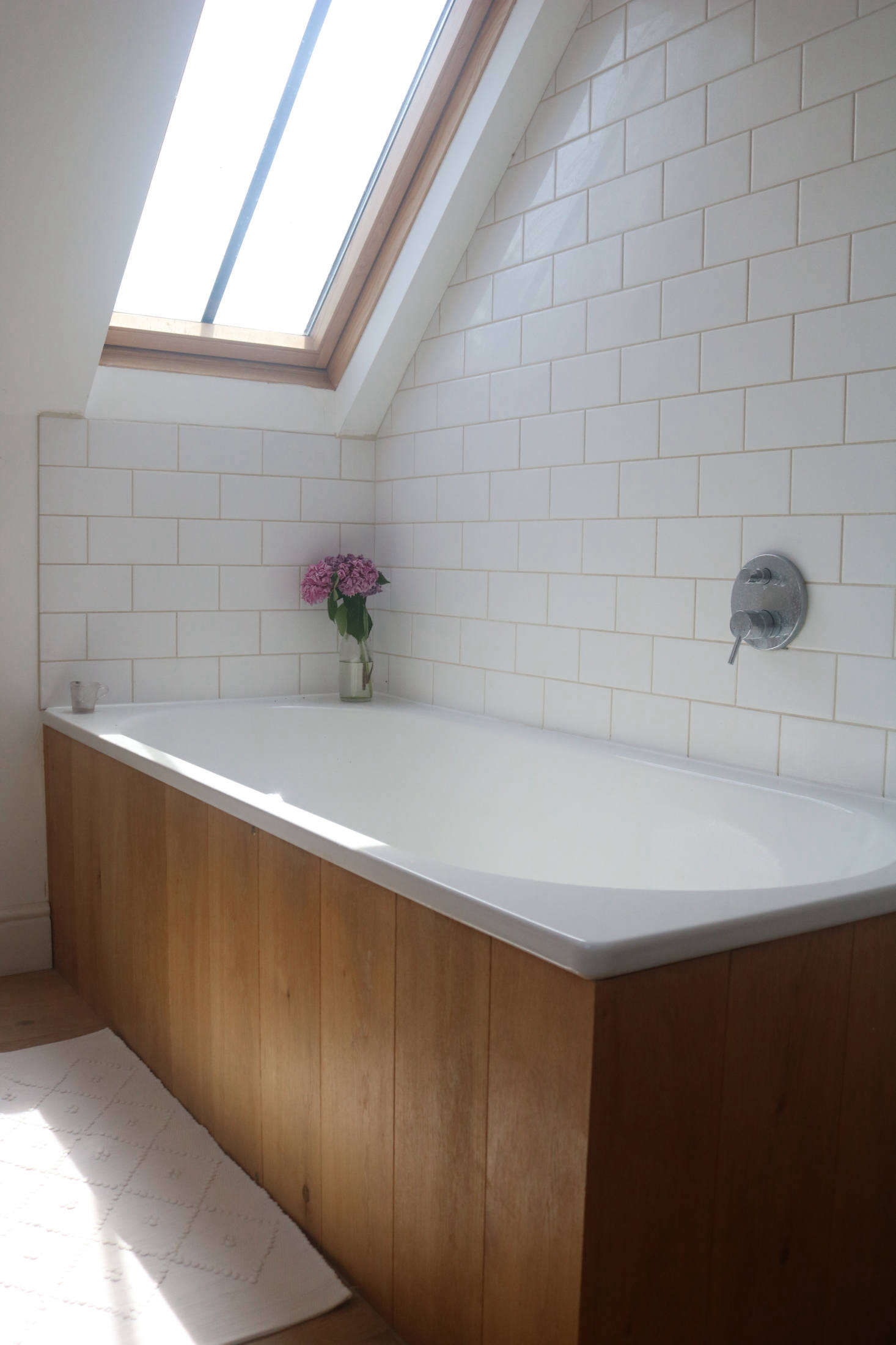 The attic bath has a view of clouds and sky.