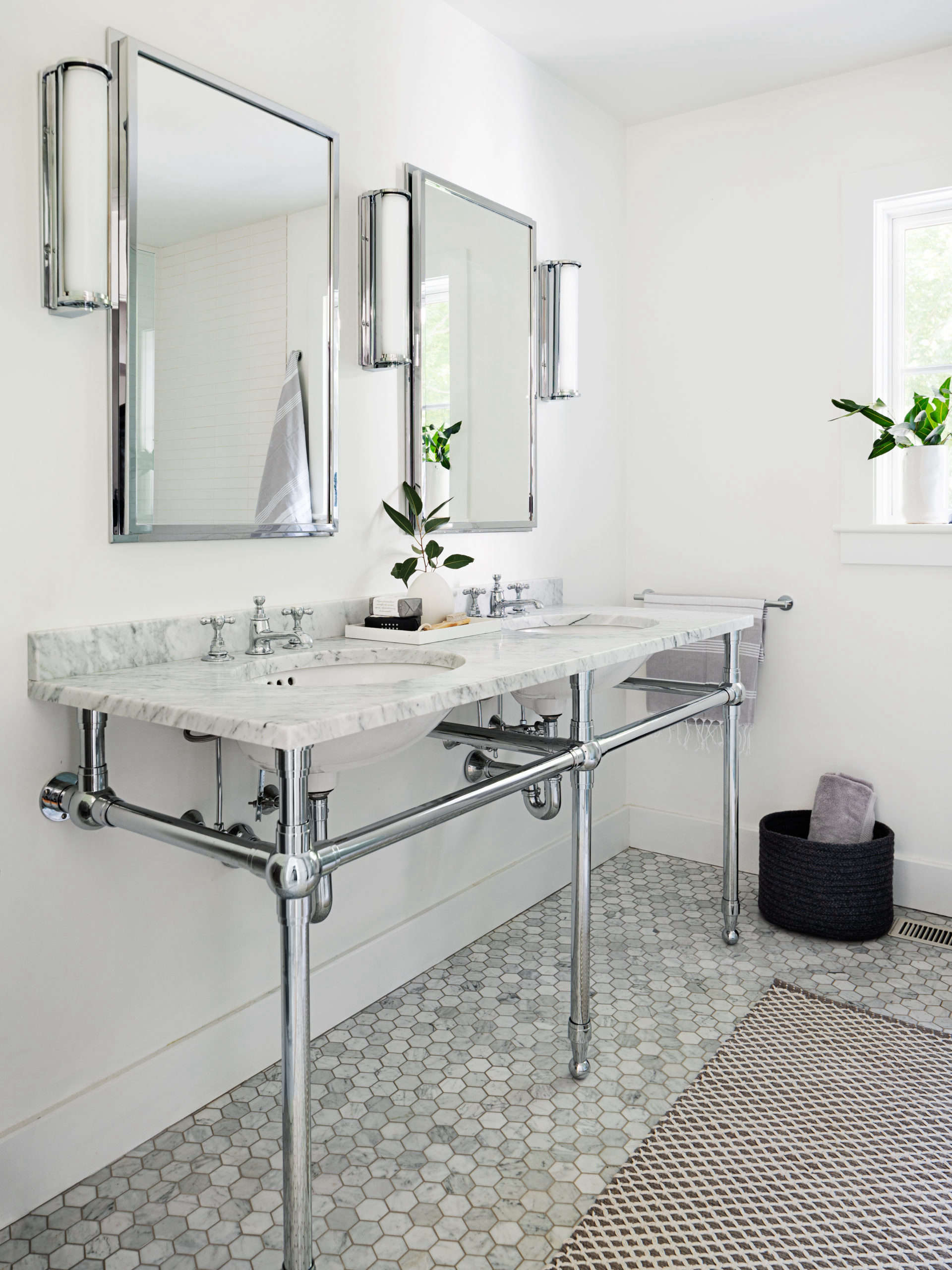 The mine-and-yours washstand is the Gramercy from Restoration Hardware with Waterworks faucets. The hexagonal marble floor tiles are from Nemo Tile.