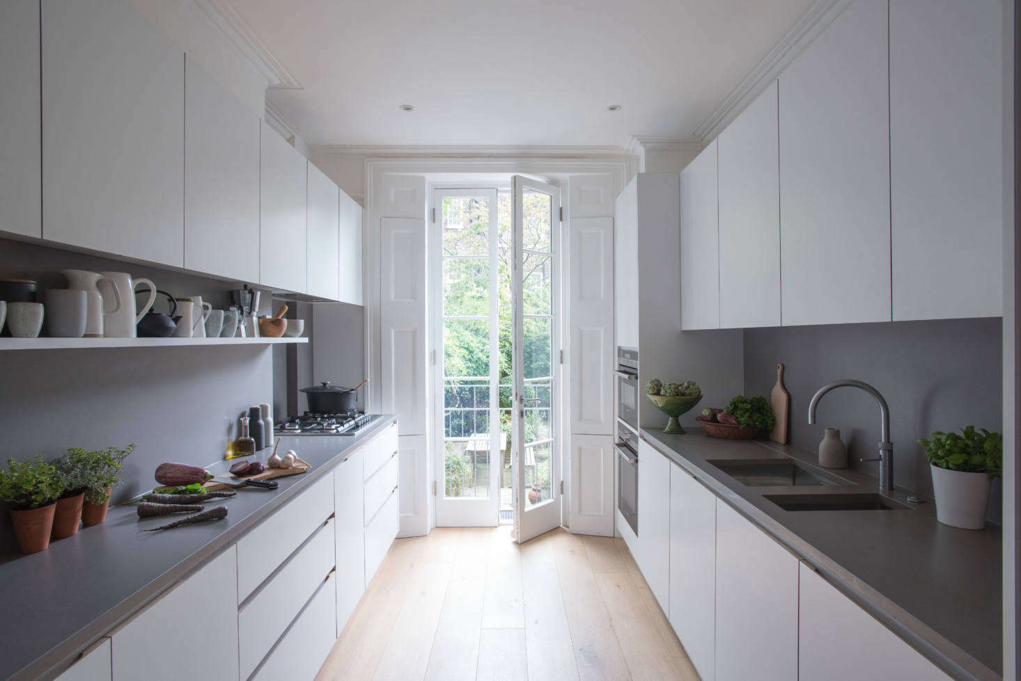 Composed of streamlined cabinets of laminate-clad MDF with oak edging, the kitchen has windows at either end: the French doors overlook an eating area and garden. The design is known as the JT Original.