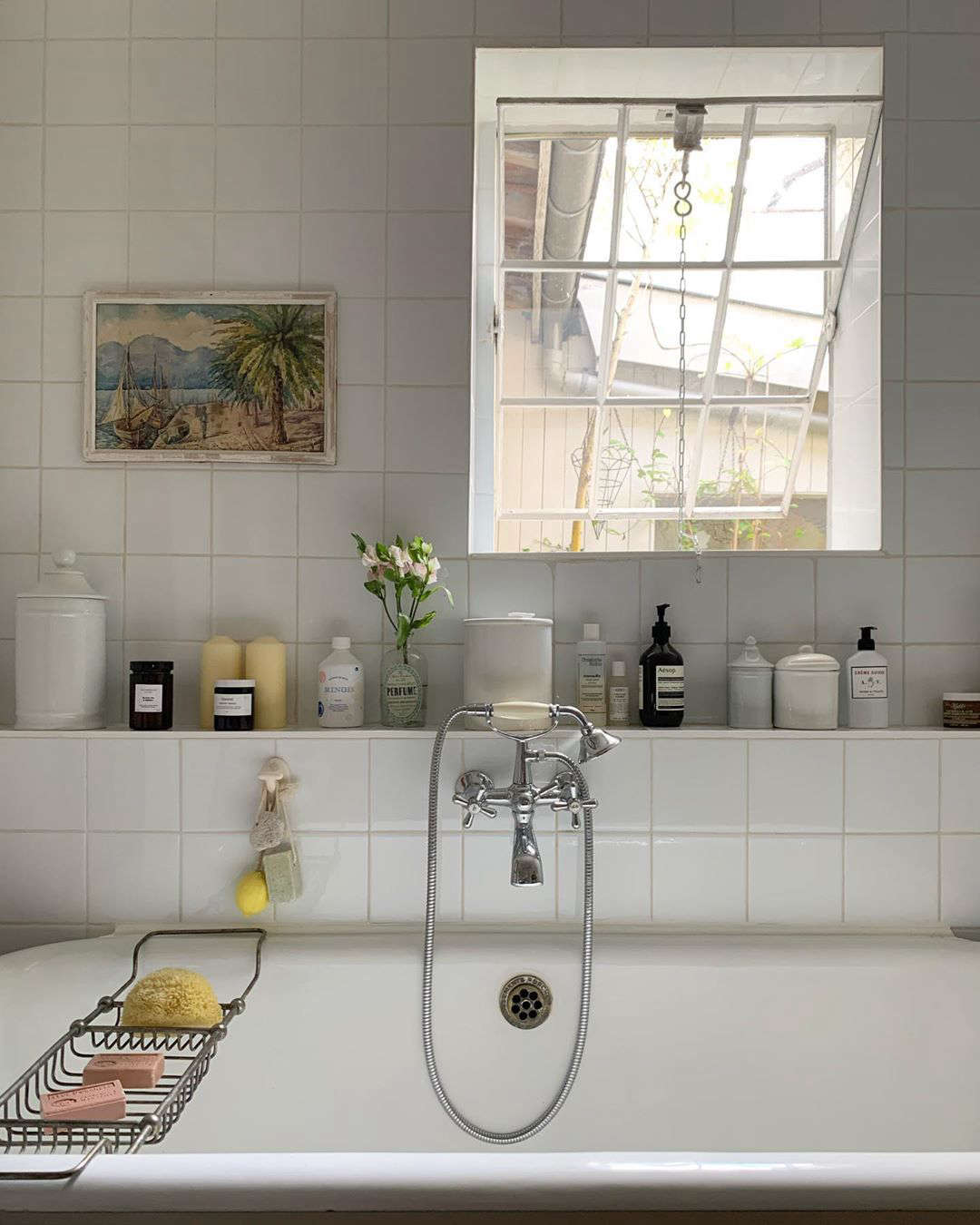 The bath, with a ledge for keeping favorite products (and a few stems of flowers).