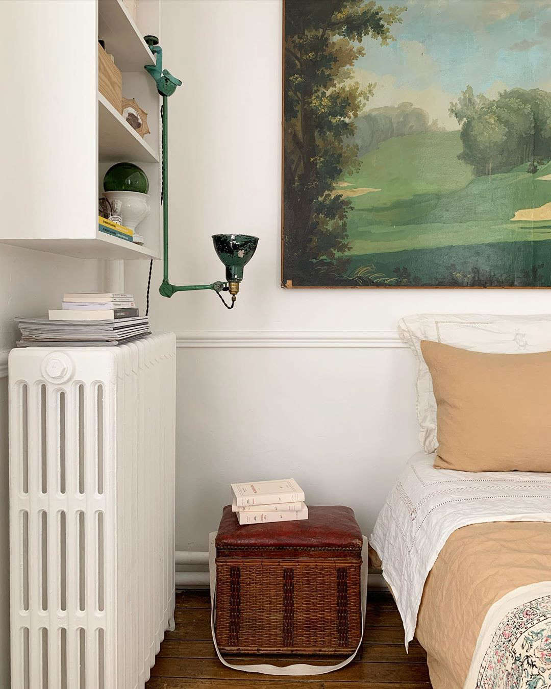 A bedroom with an unexpectedly upturned task light and basket as nightstand.