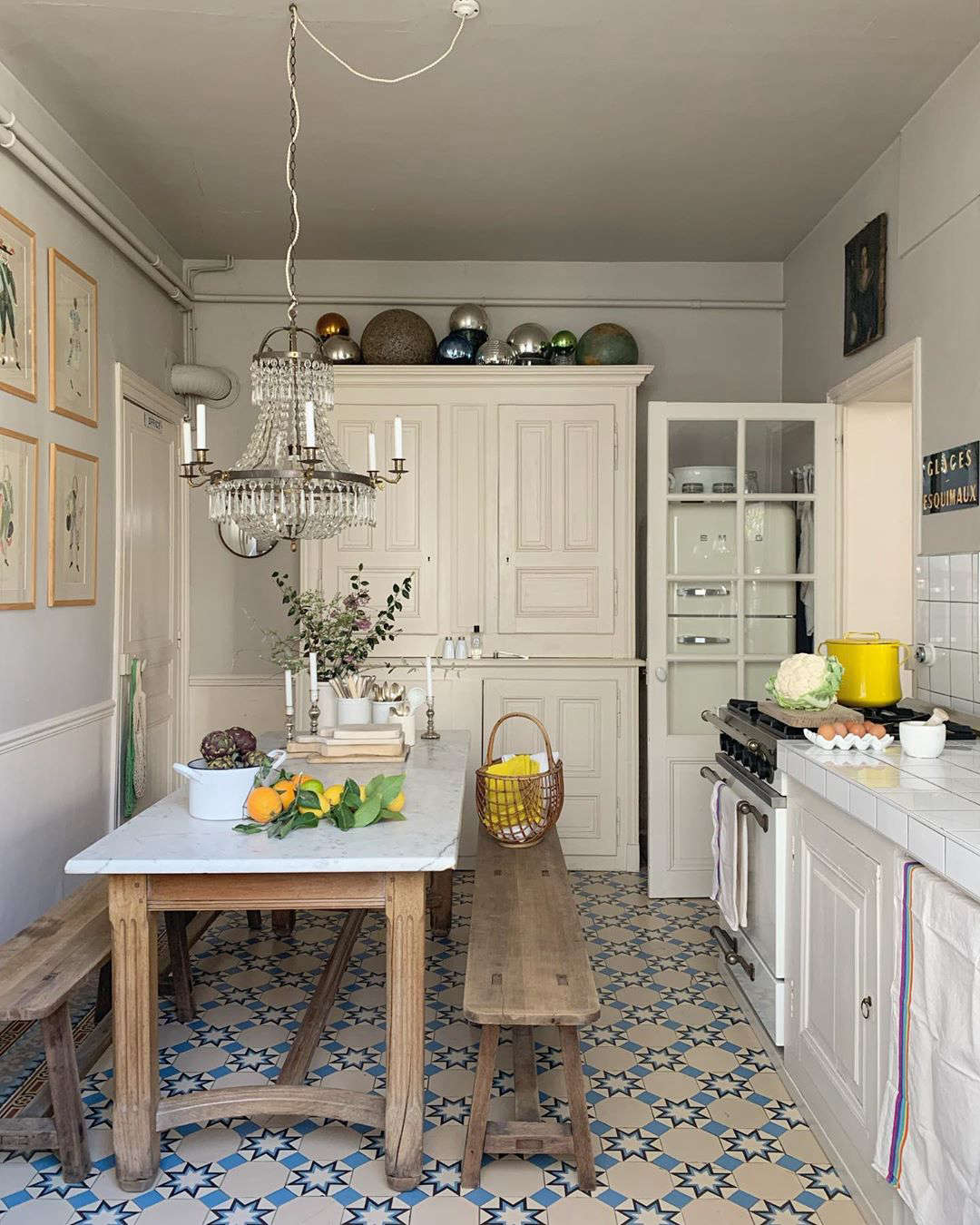 The petite kitchen, with glimpses of color (in a cloth, a yellow pot, a hanging market bag).