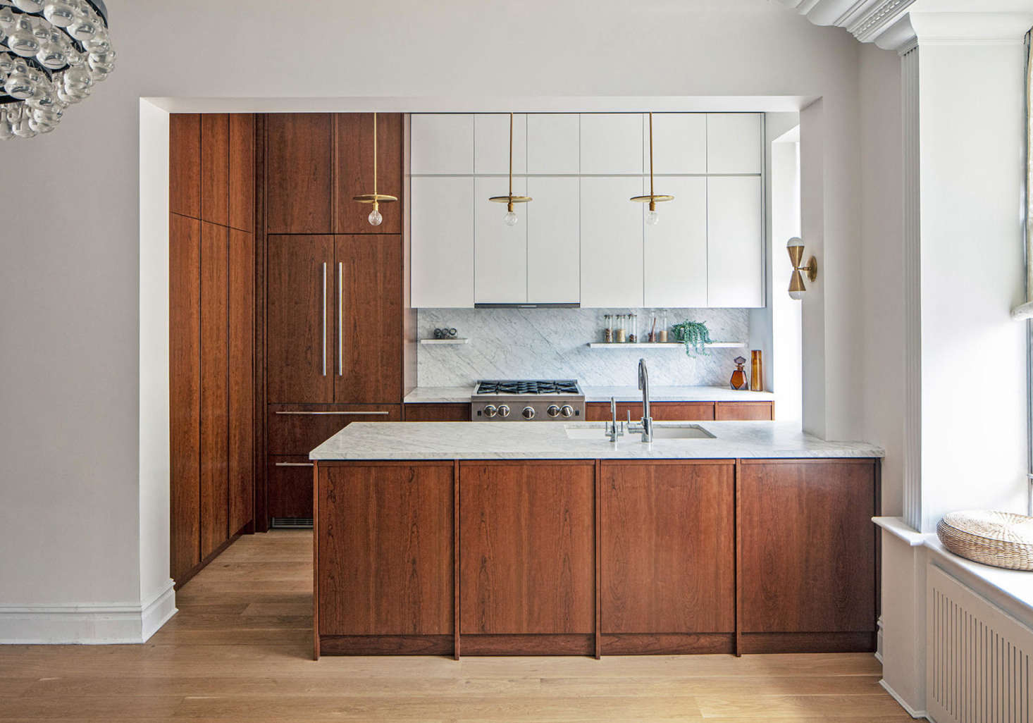 The mandate for the kitchen was plenty of storage and a sleek but inviting look: Barbara, who is from Italy, campaigned for warmth; Jakob, who is Swedish, likes logic and order. Inspired by an old mantel opposite the kitchen, the three settled on a cherry finish for the majority of the cabinets, 