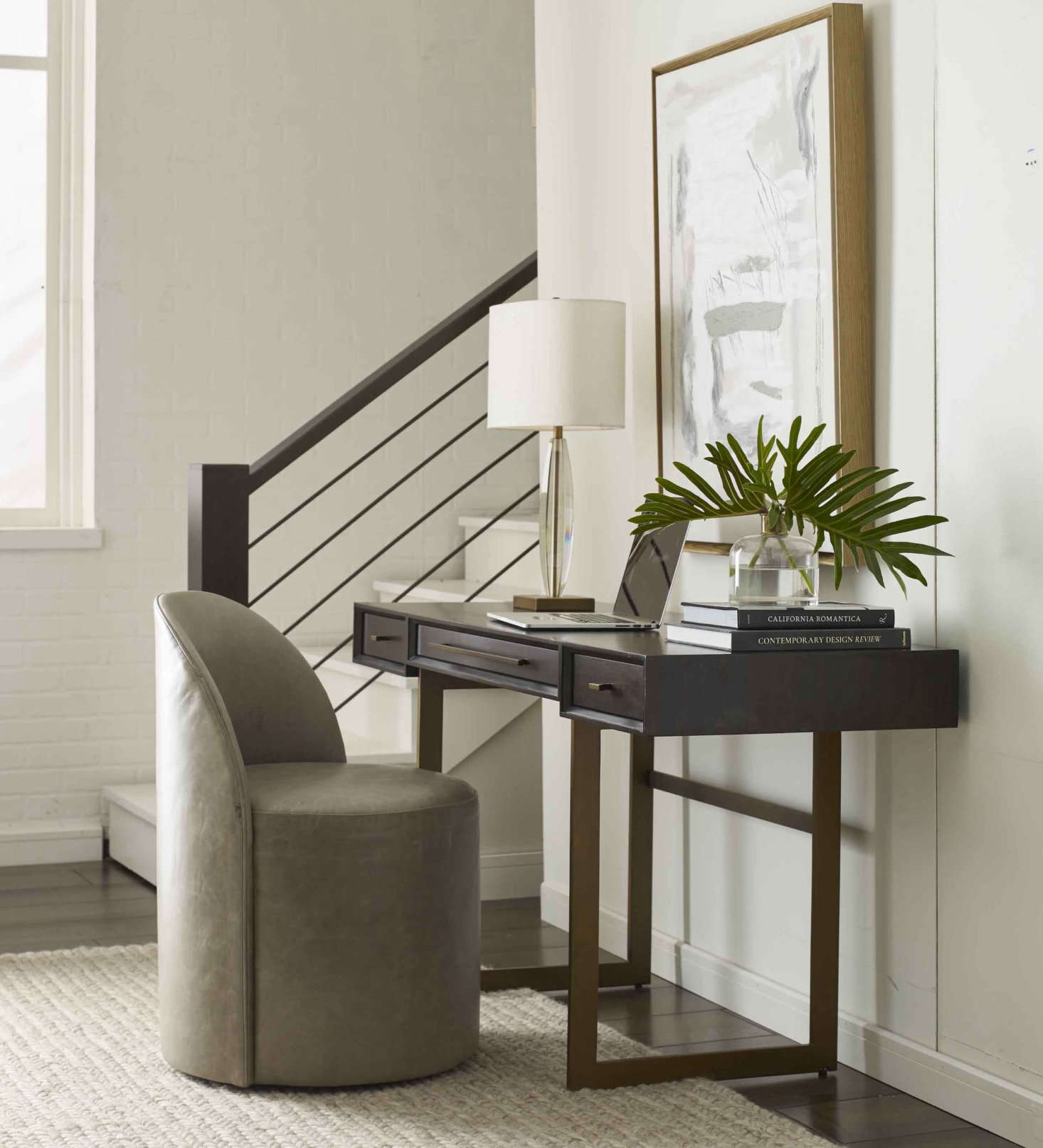 The Allure Desk—shown here with a dark smoked eucalyptus top and brass base—has a slim profile but a generous surface and creates an efficient, good-looking work-from-home setup in any room.