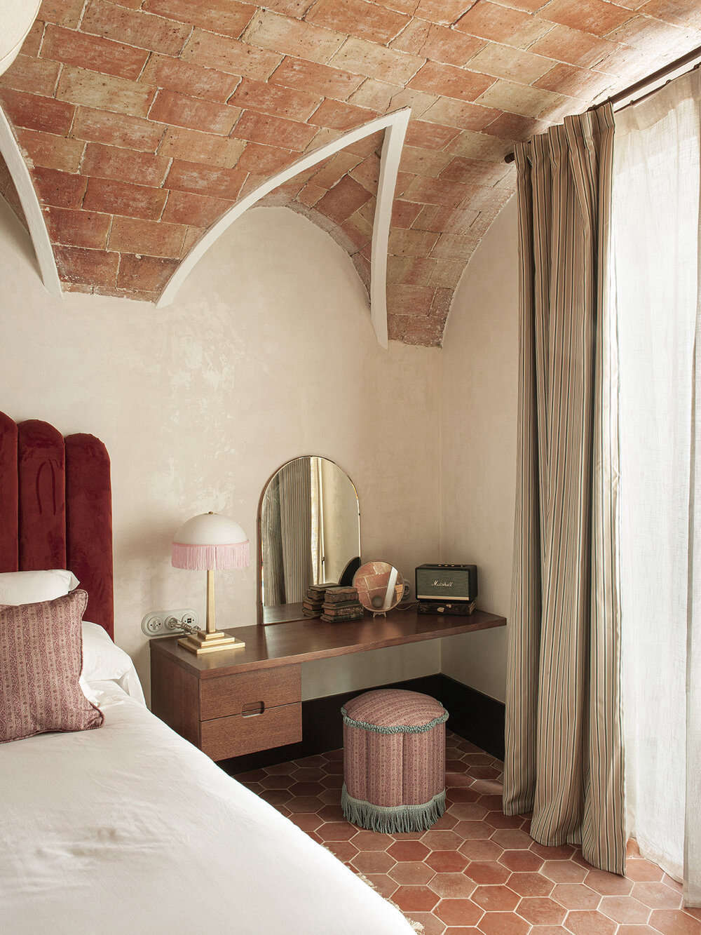 A bedside vanity with the original ceiling and tiled floor in one of the eight rooms. None are alike, and each is named for an interesting early-th century woman from history—this one is Victor.