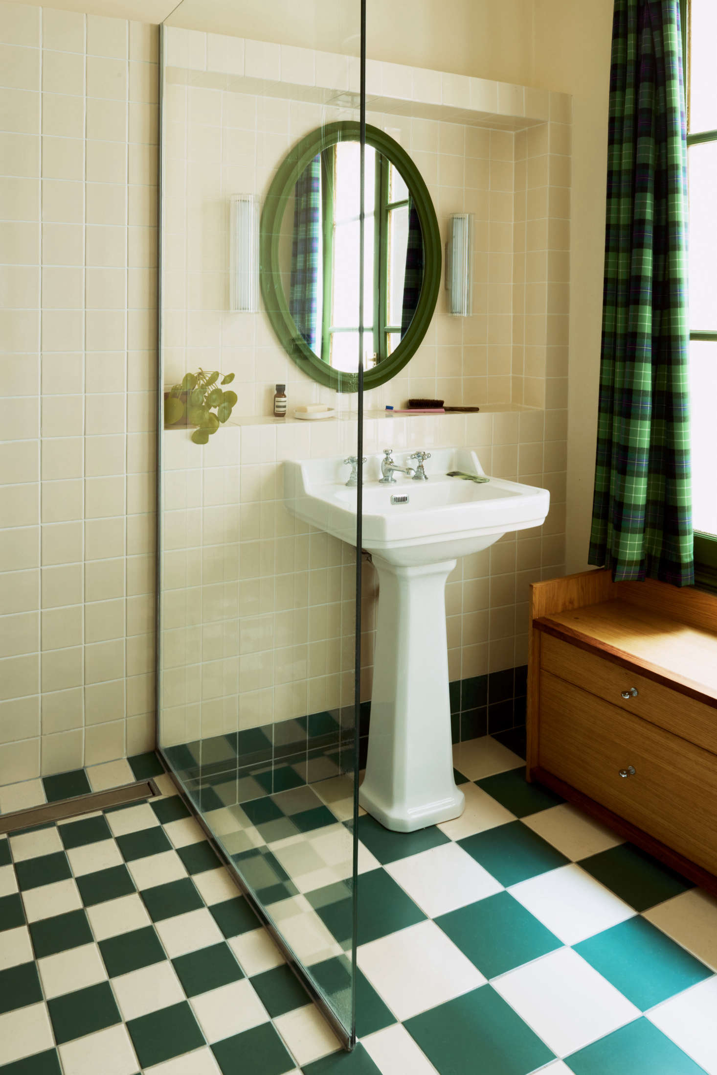 The green theme continues in the bathroom, where the bespoke drawers serve as both storage and a bench.