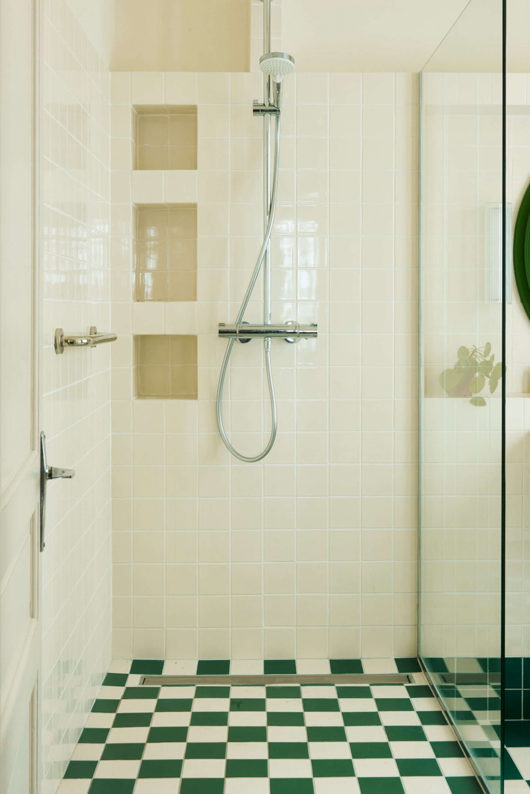 The glass shower is thoughtfully detailed with tiled niches.