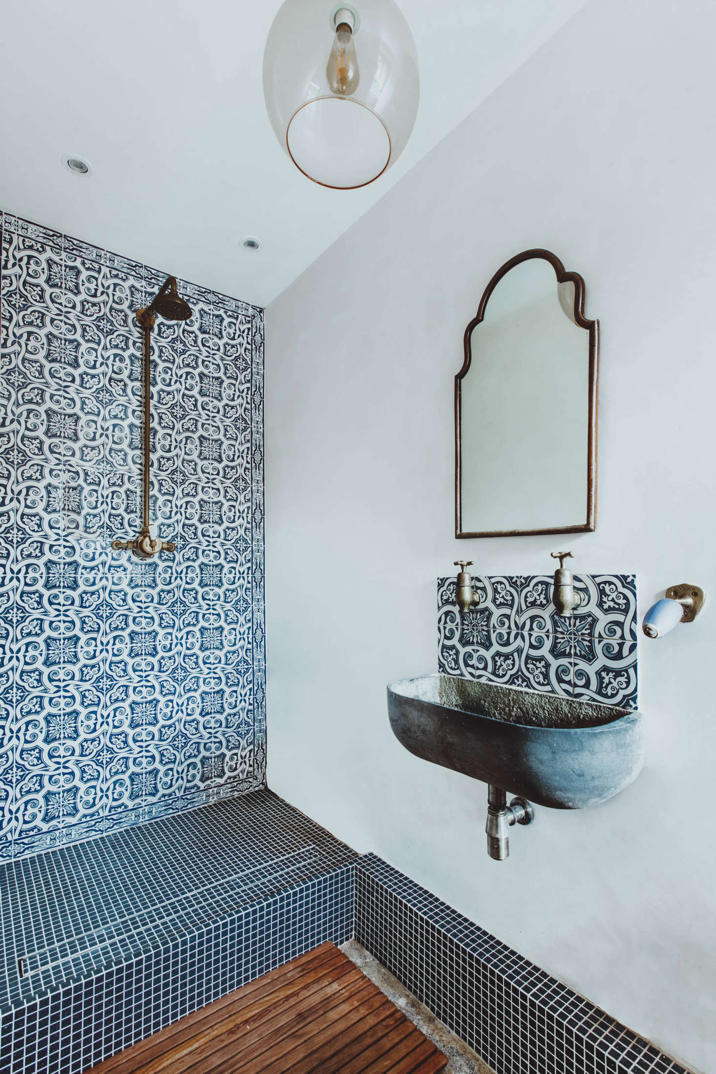 In one bath, the shower is tiled with Portuguese azulejo tiles. 