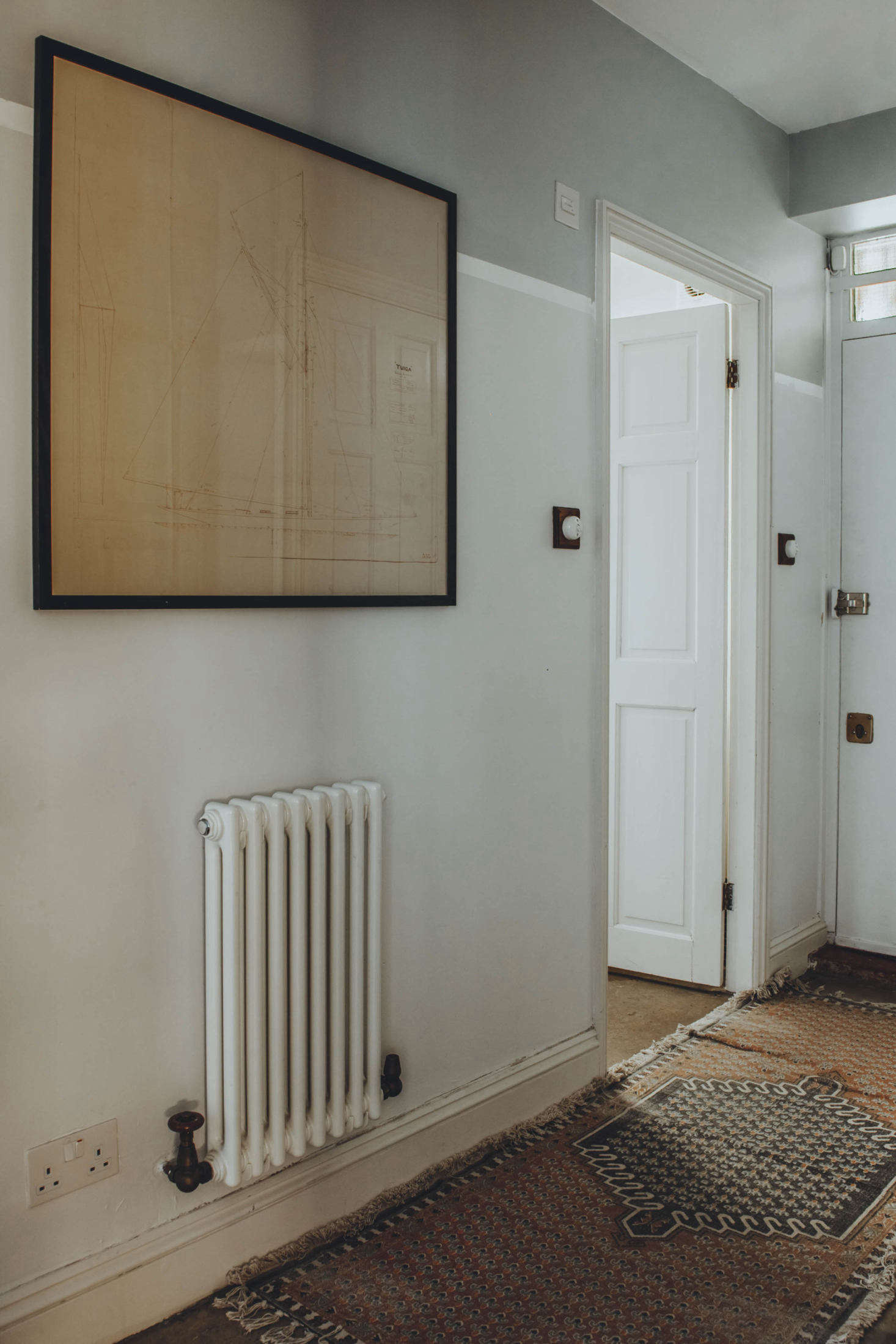 The hallway, layered with antique rugs.
