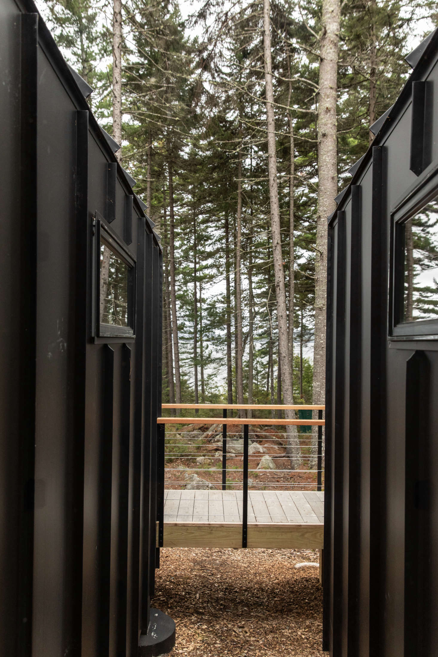A breezeway area between the two rooms frames a view of the pines.