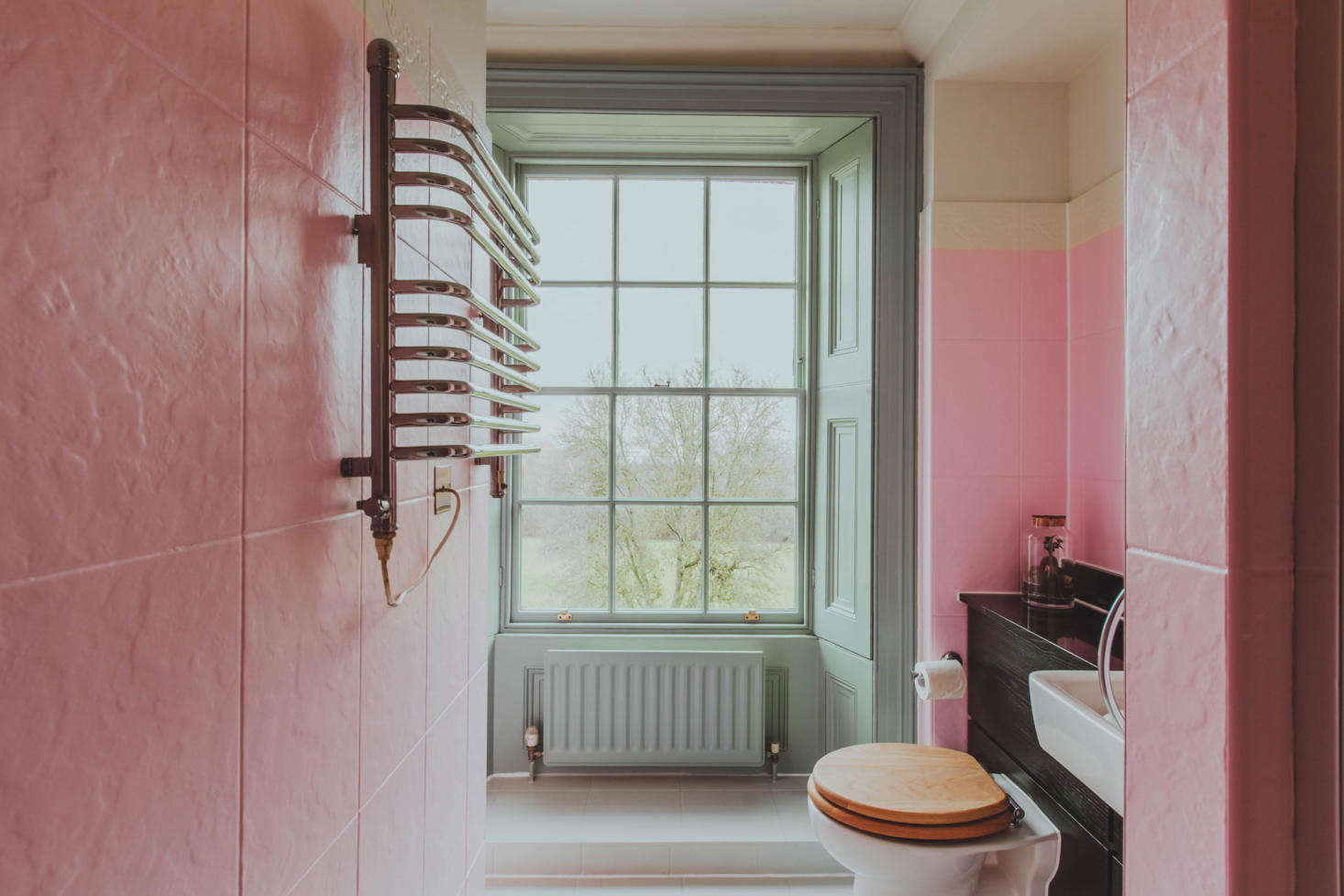 A bright pink tiled bath.
