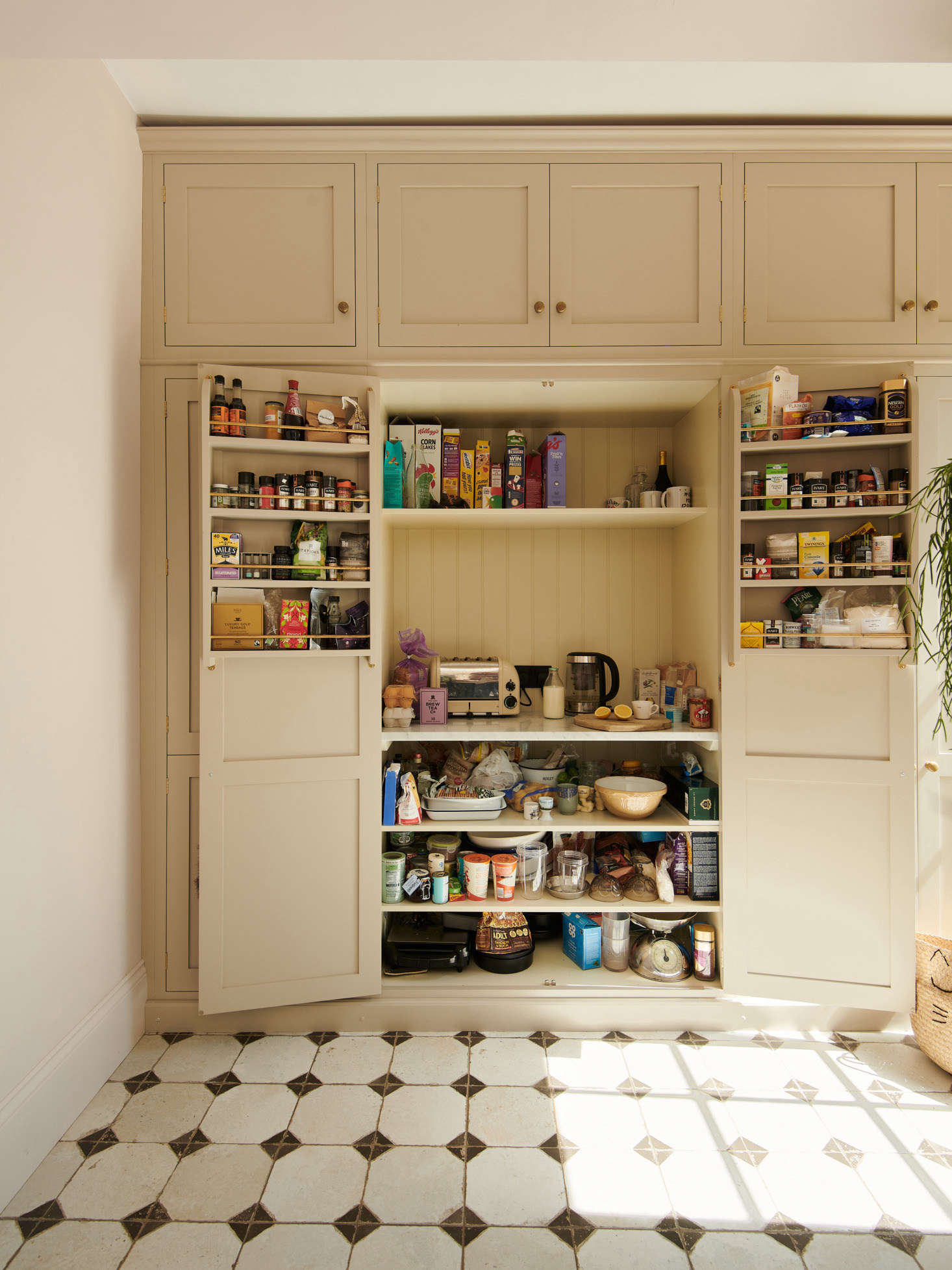 Adjacent to the refrigerator is the pantry. An electrical outlet inside means Chris can store the toaster and tea kettle on the middle shelf.