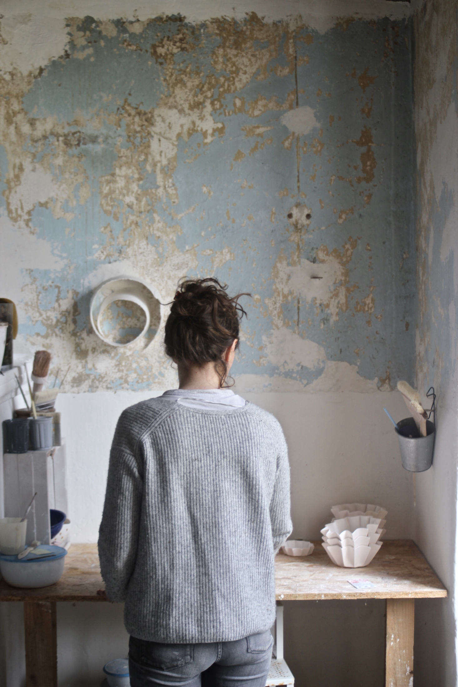 Justine glazes Canele Cups in front of a preserved old wall 
