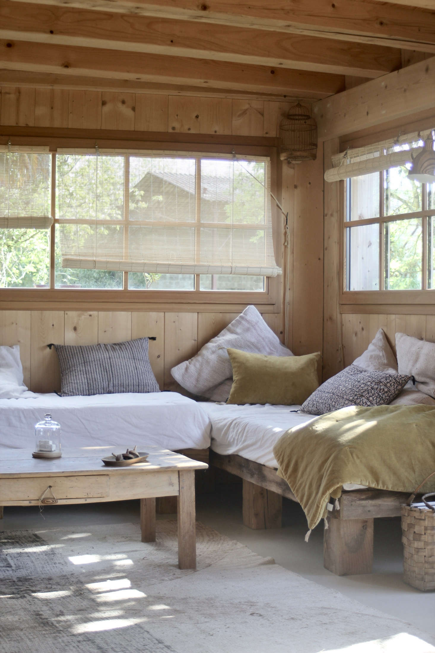 Jean built the living room daybeds out of wood from the old roof, and the couple installed the horizontally-oriented windows themselves. 