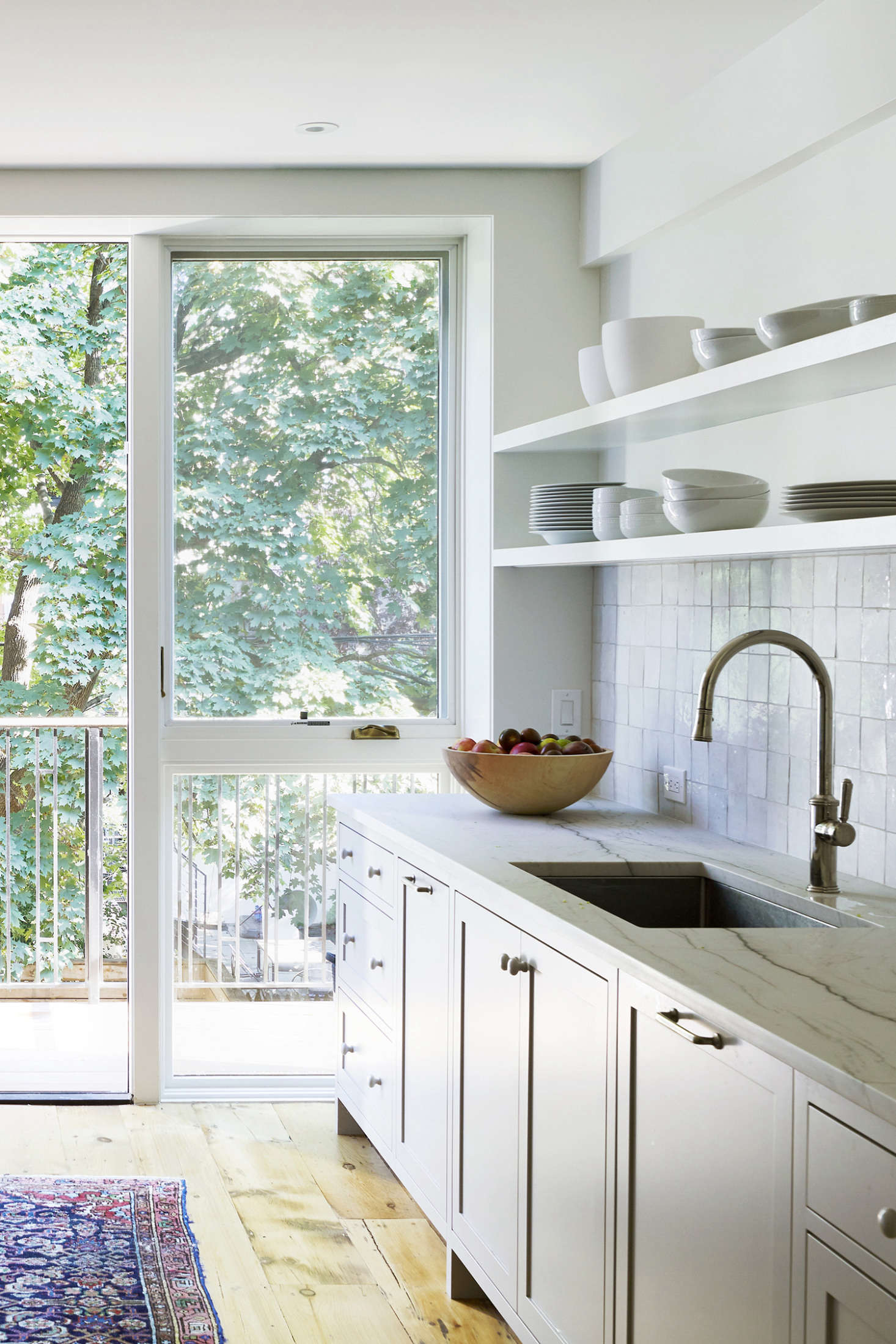 The owners are avid cooks and bakers; in lieu of a work island, they asked that the counters be extra deep. The cabinets are a custom design with Aria Quartzite counters from SMC Stone. The kitchen woodwork was shop spray-painted in Farrow & Ball