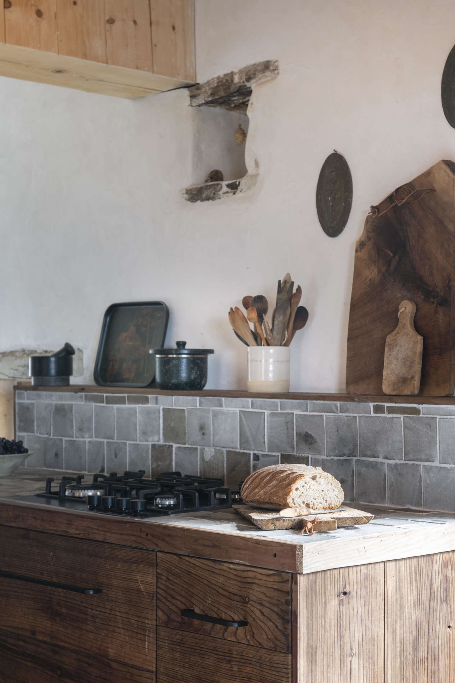 The couple say they were very happy when their cat left its prints on the kitchen tiles as they were being made. The favorite cooking pot on the shelf is stone by Soh Style of Korea.