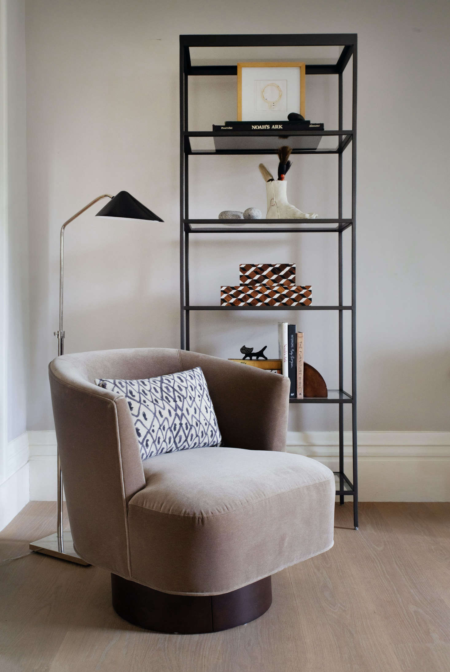 At the last minute, Justine pulled in a Costello Swivel Chair (in an easy-care performance velvet) to turn an unused corner into another space for working or relaxing. “We’re all making the most of our homes now and need furnishings to help rooms multitask,” says Allison. “The midcentury-inspired swivel chair is ideal for creating a quiet corner in a busier shared space.” Alongside is the clean-lined Vienna Bookcase—slender enough, at only inches deep, for small spaces—with Checkered Boxes (a perfect place to tuck chargers or remotes) and a few of Justine’s favorite objects.
