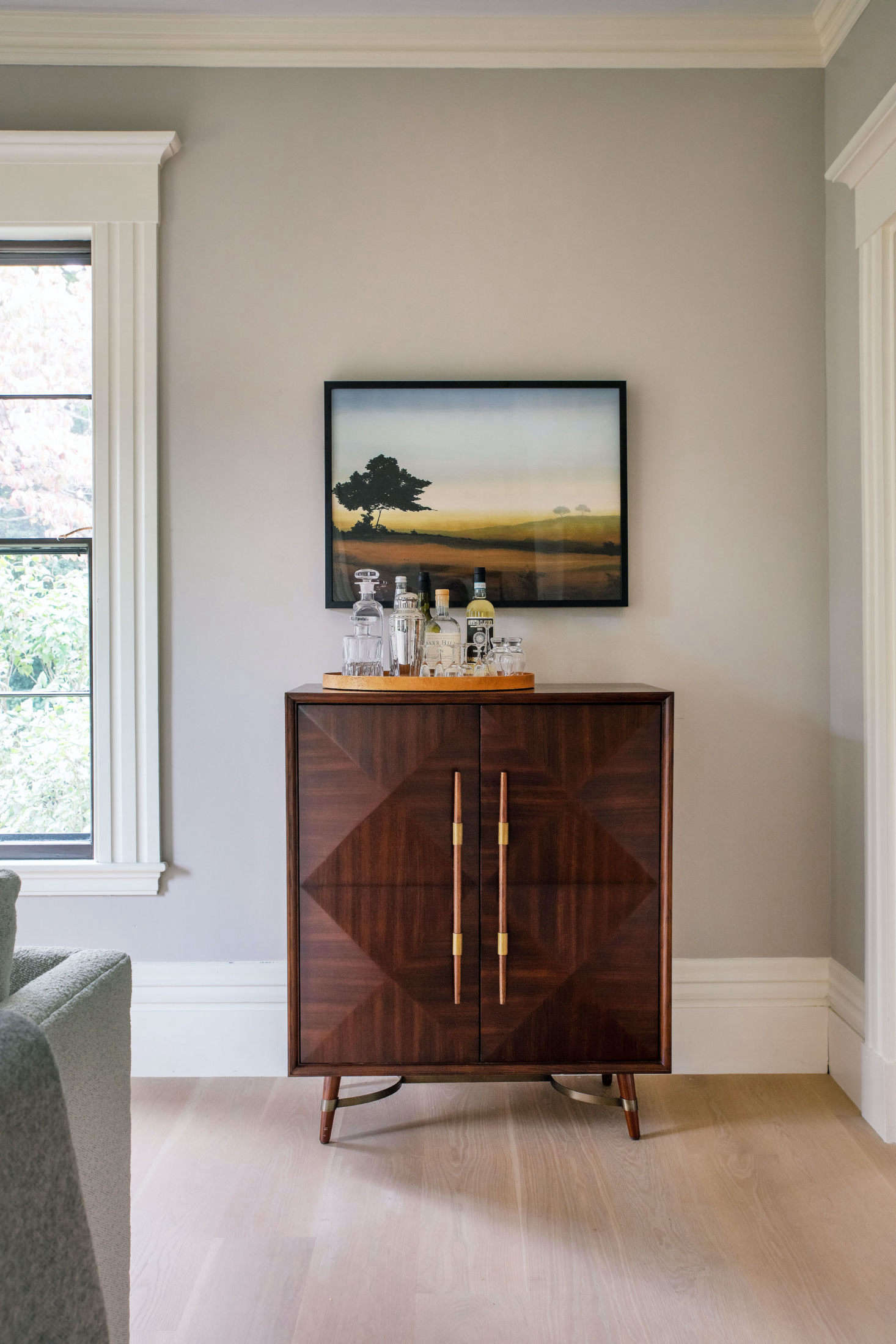In another corner is the Lasalle Bar, with raised parquet-patterned doors and antiqued brass accents and topped with Justine’s own vintage barware. “I was looking for something complimentary in the MG+BW collection to go with the vintage painting of the girl,” says Justine; she opted for Golden Glow, a signed limited-edition print of a work by American artist Robert Charon.