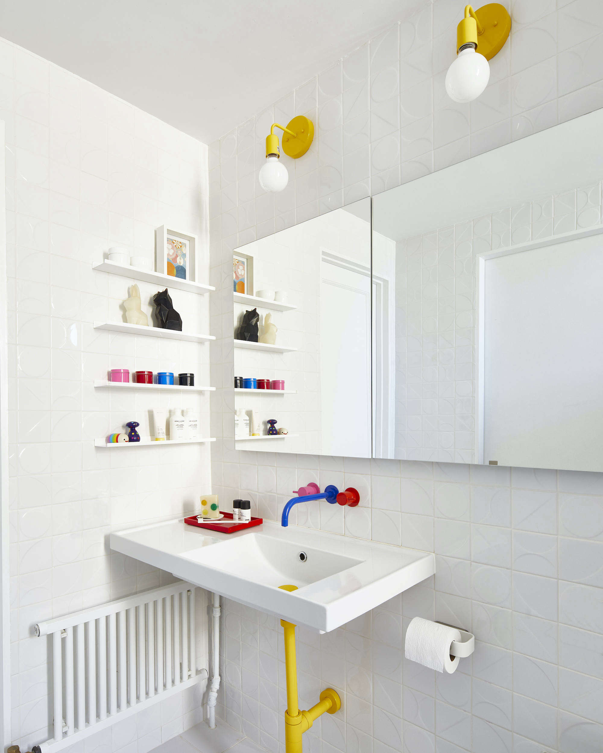 the geometric bathroom is anchored with a white canvas and layered with bright, 18