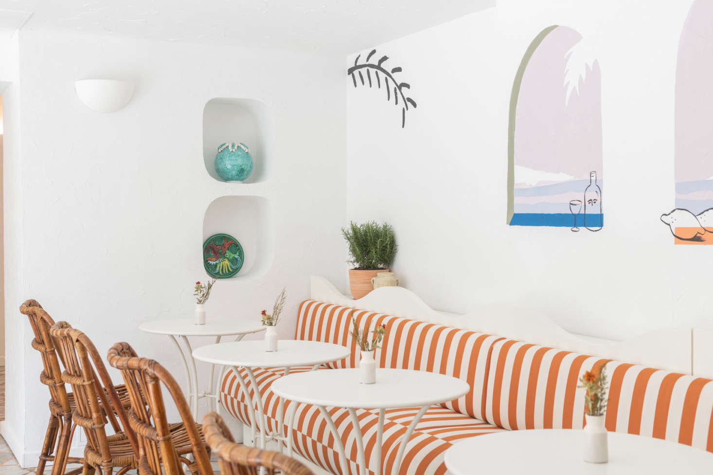 French artist Franck Lebraly painted a whimsical mural above the striped banquette in the cafe.