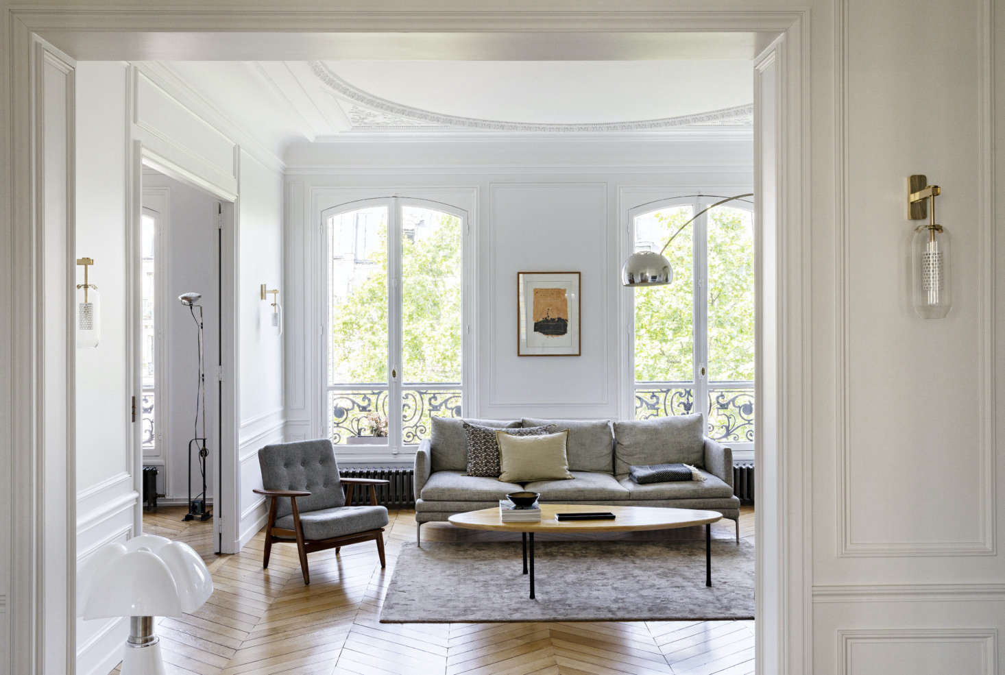 Filled with neutral tones, the living room draws the eye to the oversized arched windows that let natural light fill the space.
