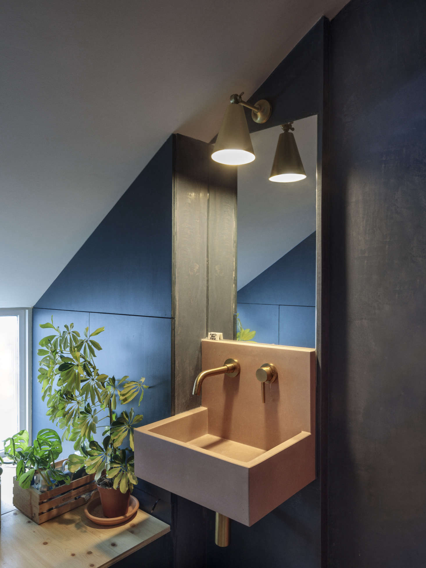 The en suite wash area has blue tadelakt walls and a pink concrete basin, the Kern by Kast.