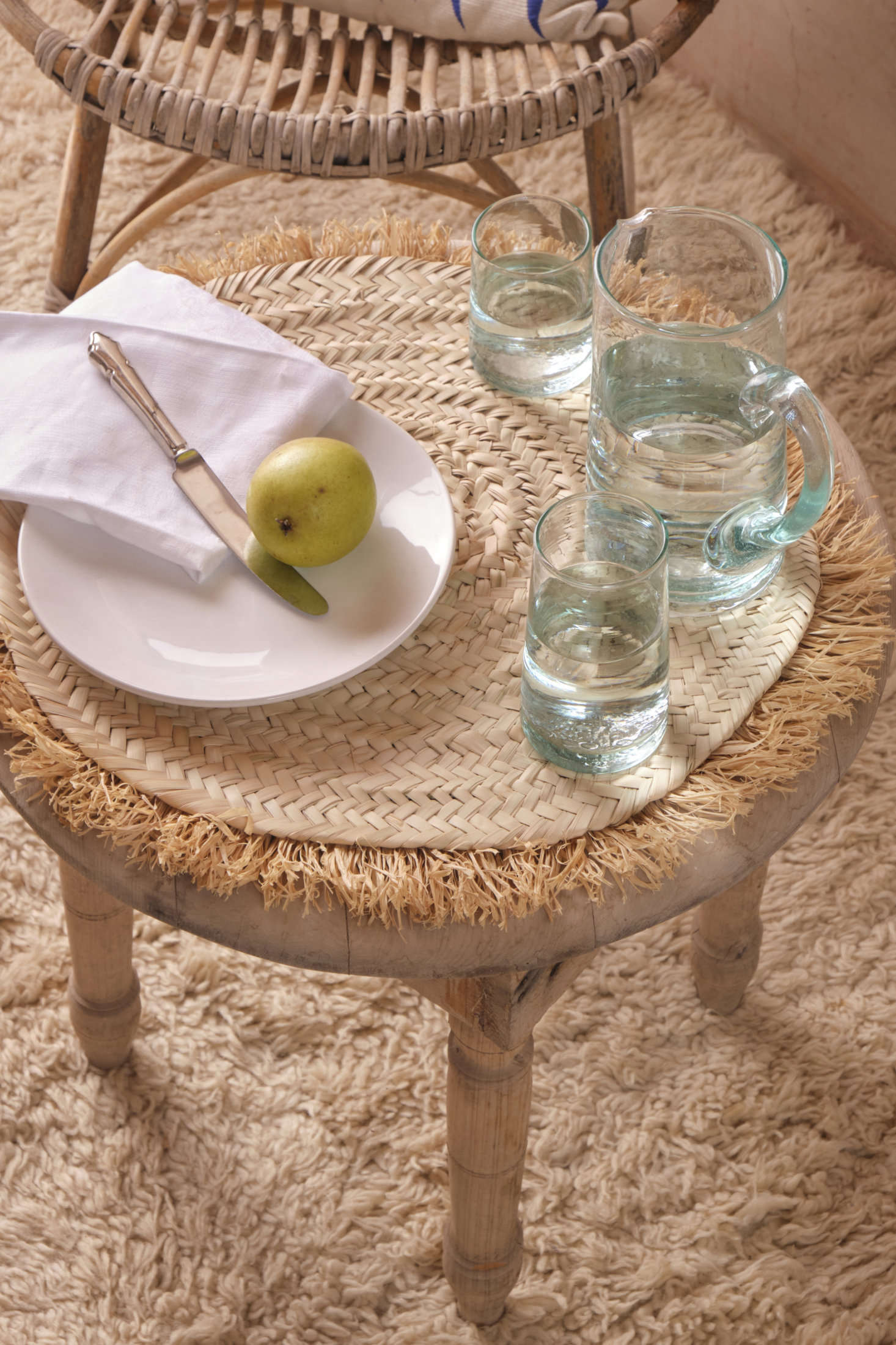 A selection of Revival’s new globally made tablewares: the Handwoven Palm Placemat ($59), handwoven in Morocco from sun-dried palm leaf with a jaunty raffia fringe, and a recycled glass Moroccan Pitcher ($39) with a sturdy handle for easy pouring. Below is a one-of-a-kind vintage Moroccan hand-knotted rug; for similar finds, head here.