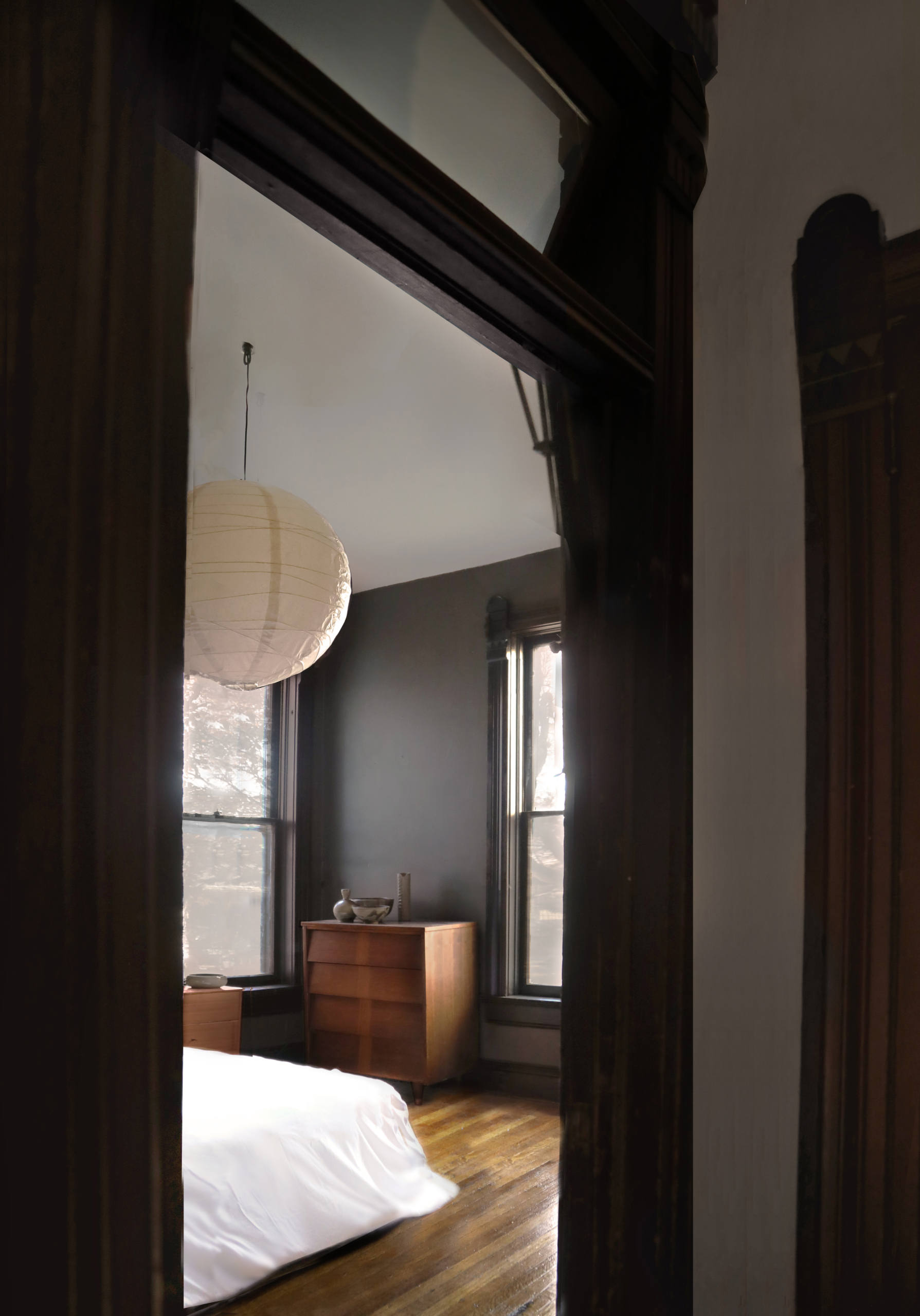 In a bedroom, another paper lantern accentuates the high ceilings.