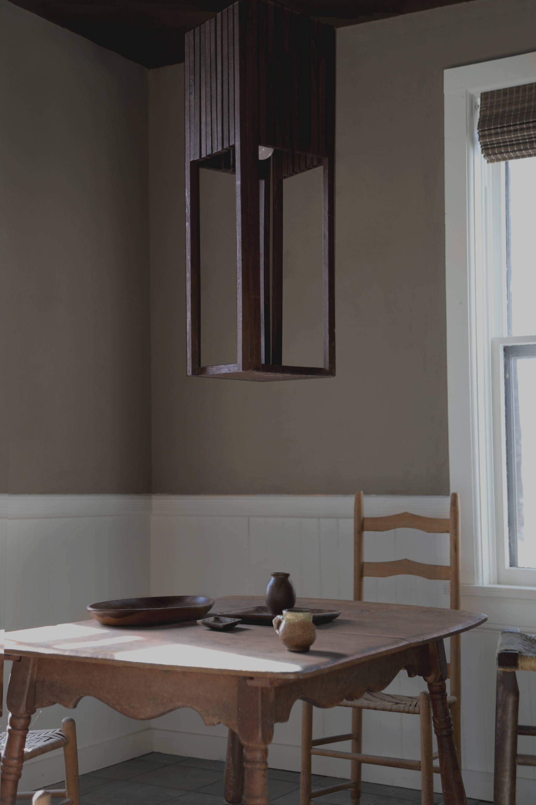 A breakfast table beneath a sculptural light fixture.
