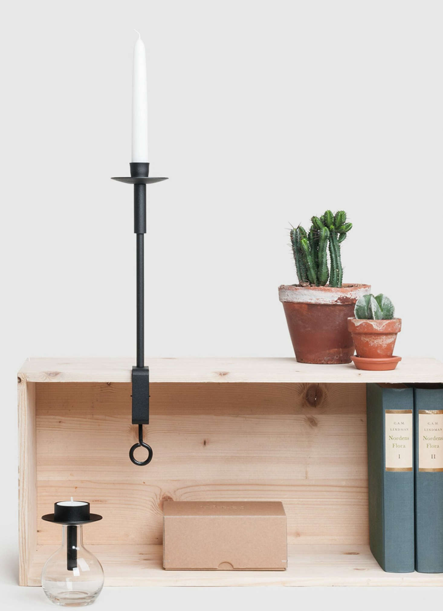 The candleholder attached to a shelf makes for a rustic lighting addition.
