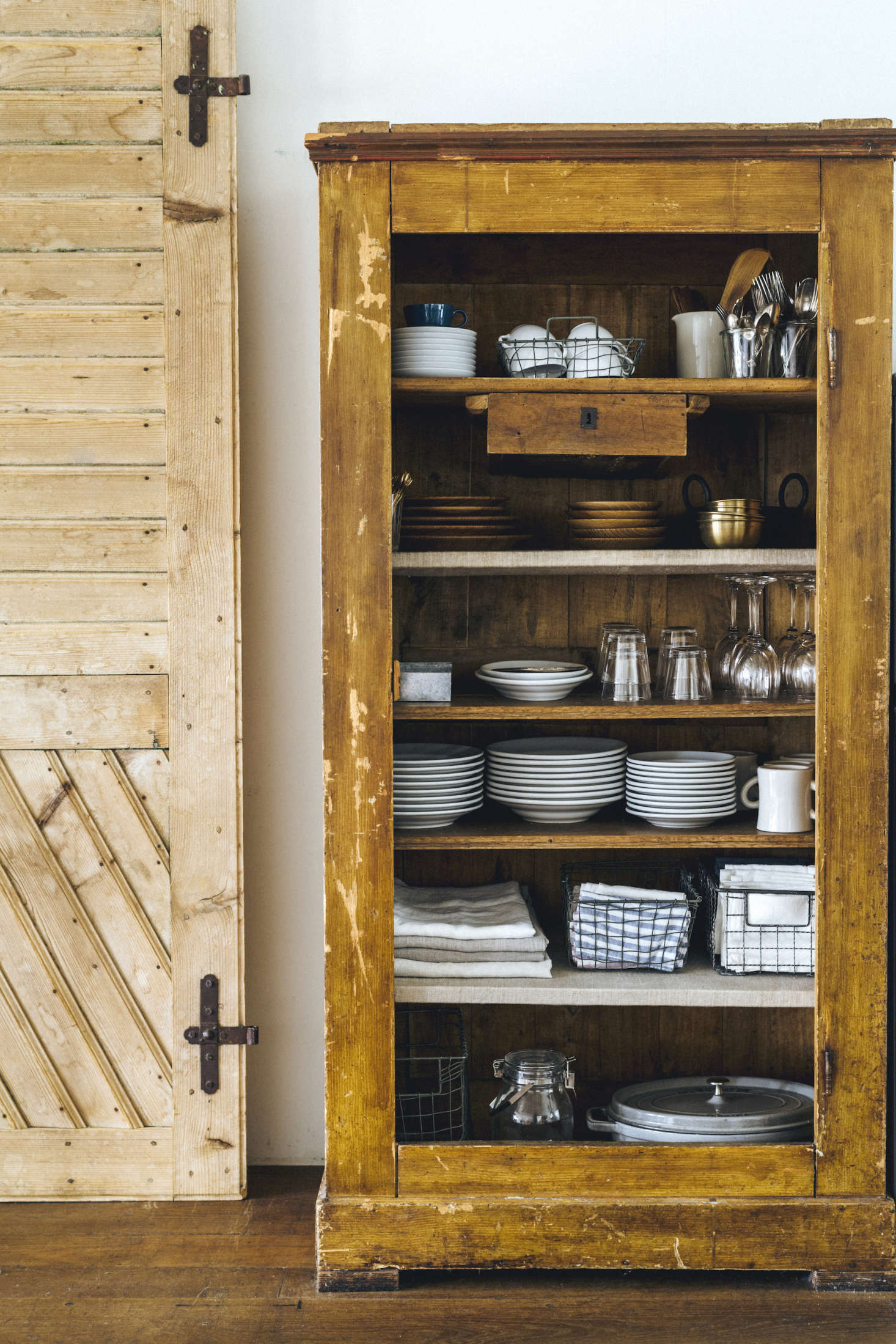 A vintage cabinet holds kitchen essentials; linens are stored in Yumiko