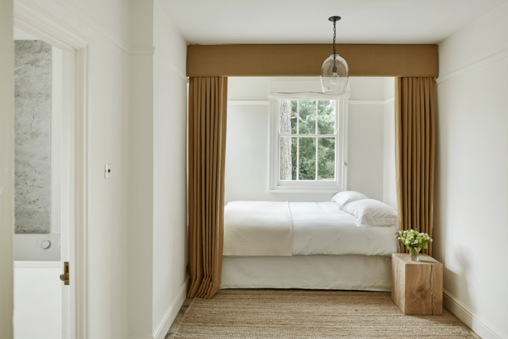 ochre curtains frame the bed in this petite bedroom. the clear lantern light is 27